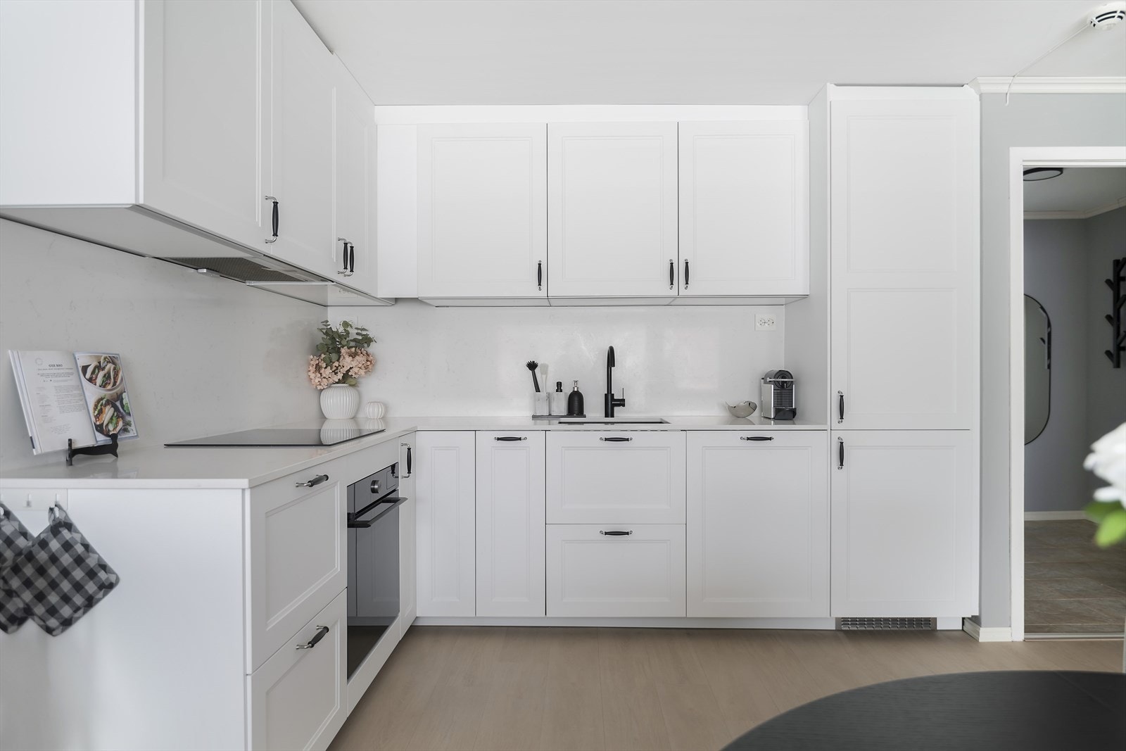 Lyst og gjennomført med profilerte skapfronter, samt benkeplate og bakplate i stein Galleribilde