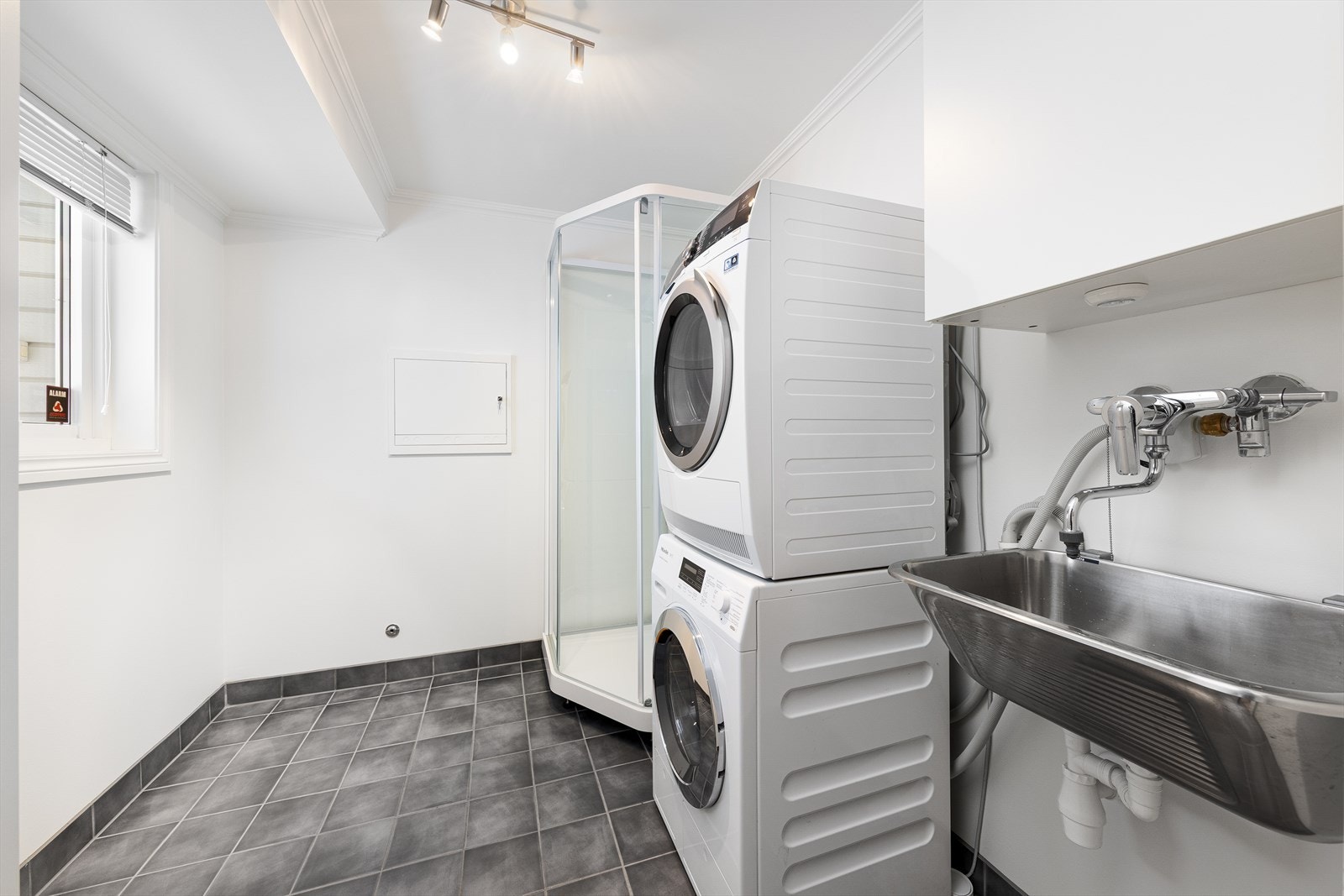 Et praktisk vaskerom med dusjkabinett, rommet ligger i forbindelse med inngangspartiet Galleribilde