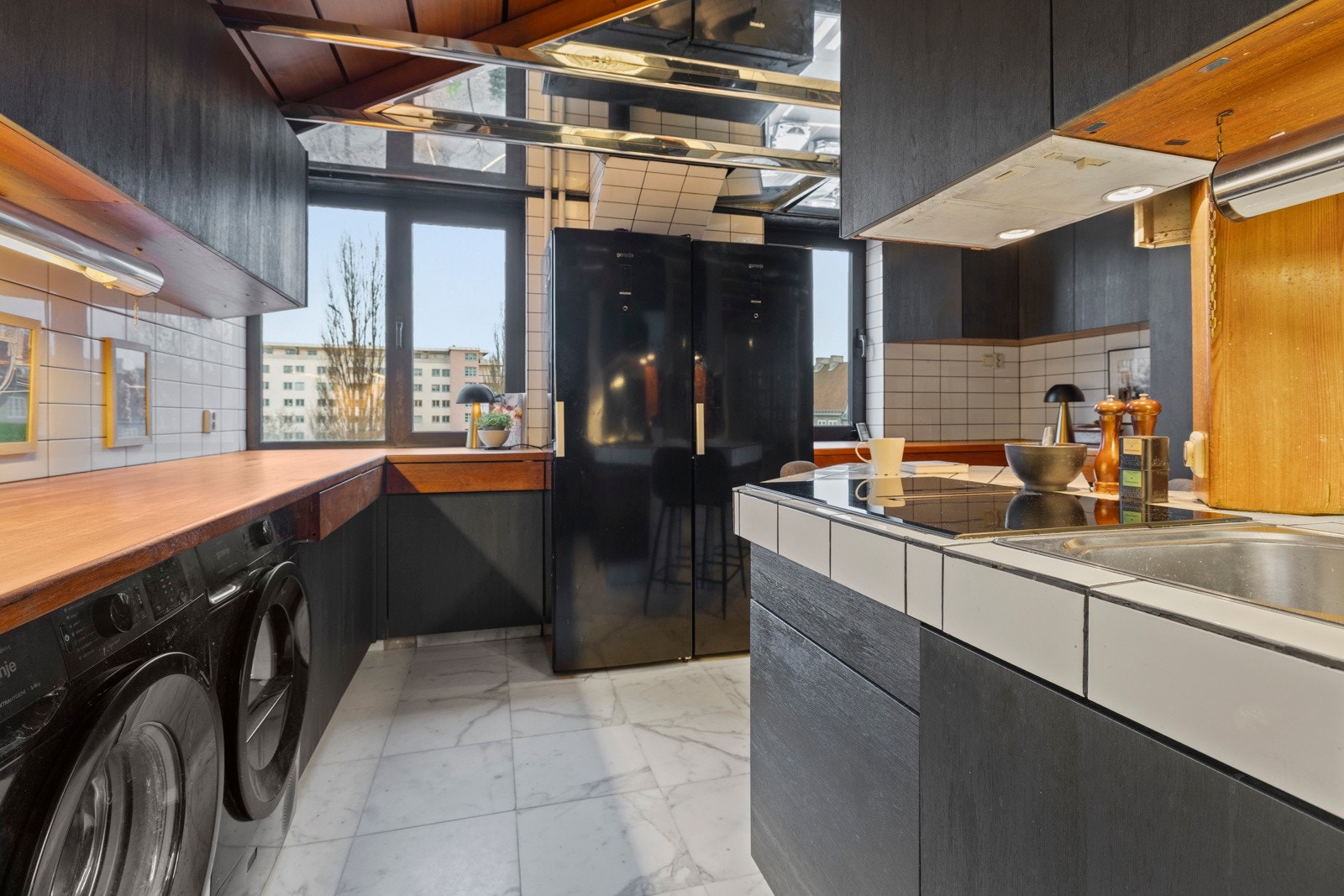 Det er benkeplate av heltre samt en flislagt flate som fungerer som en kjøkkenøy med nedfelt oppvaskkum. Galleribilde