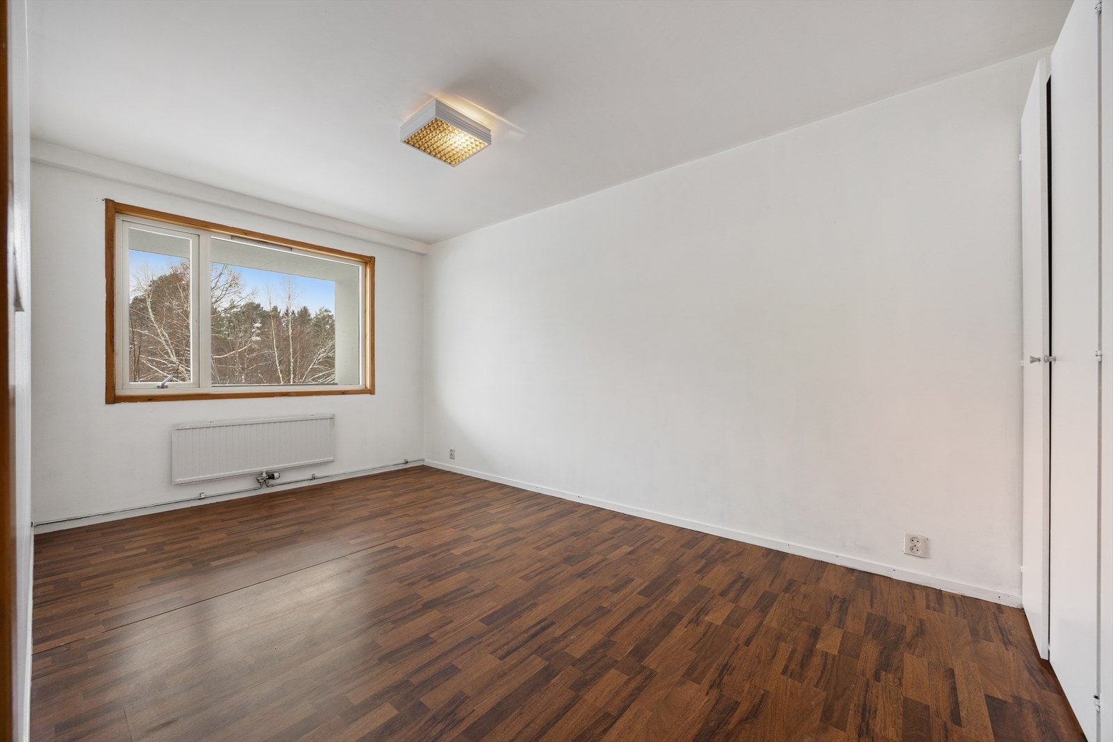 Et stort vindu slipper inn dagslys og gir utsyn mot grønne omgivelser. Galleribilde