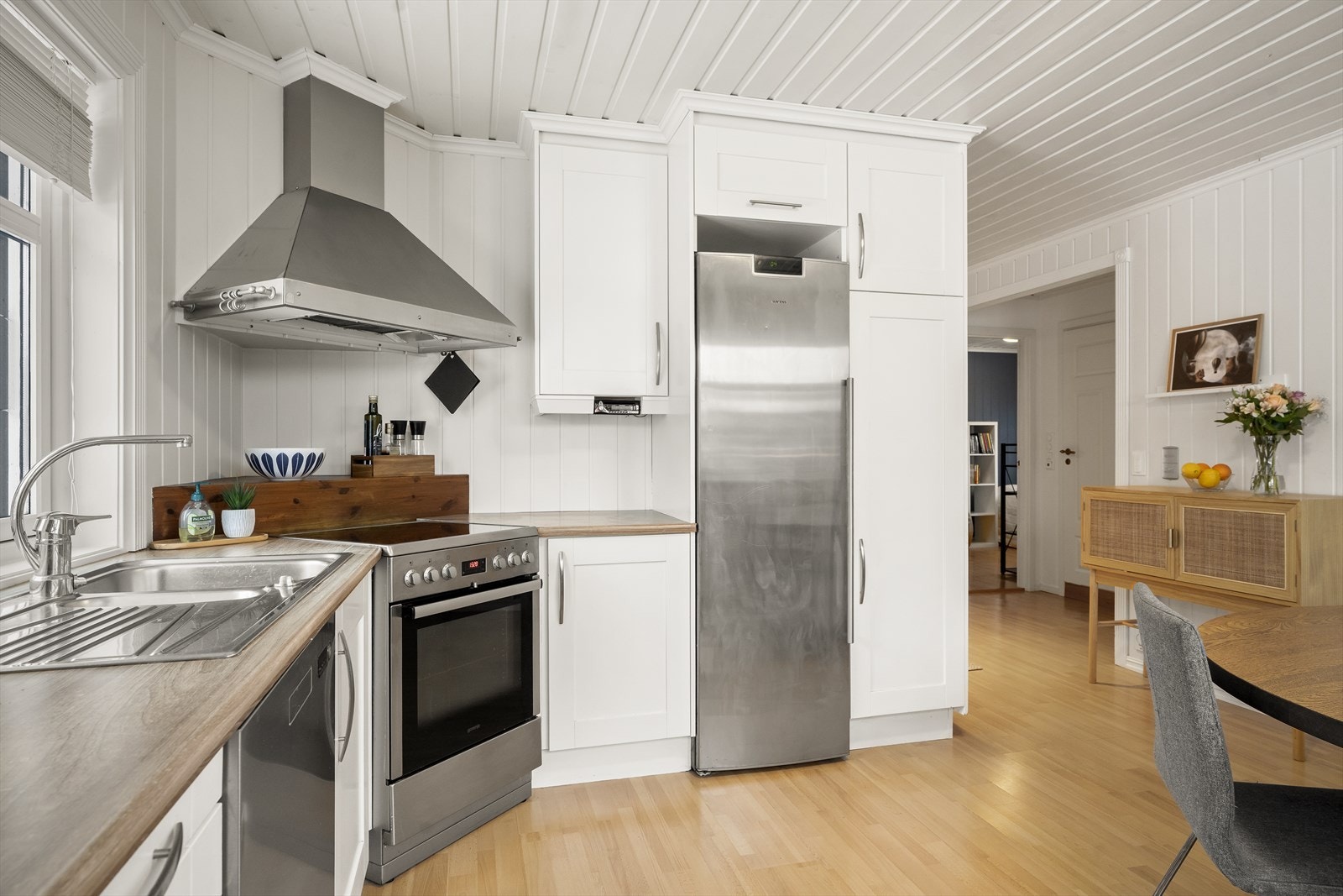 Kjøkken med god mye skap- og benkeplass og god plass til spisebord Galleribilde