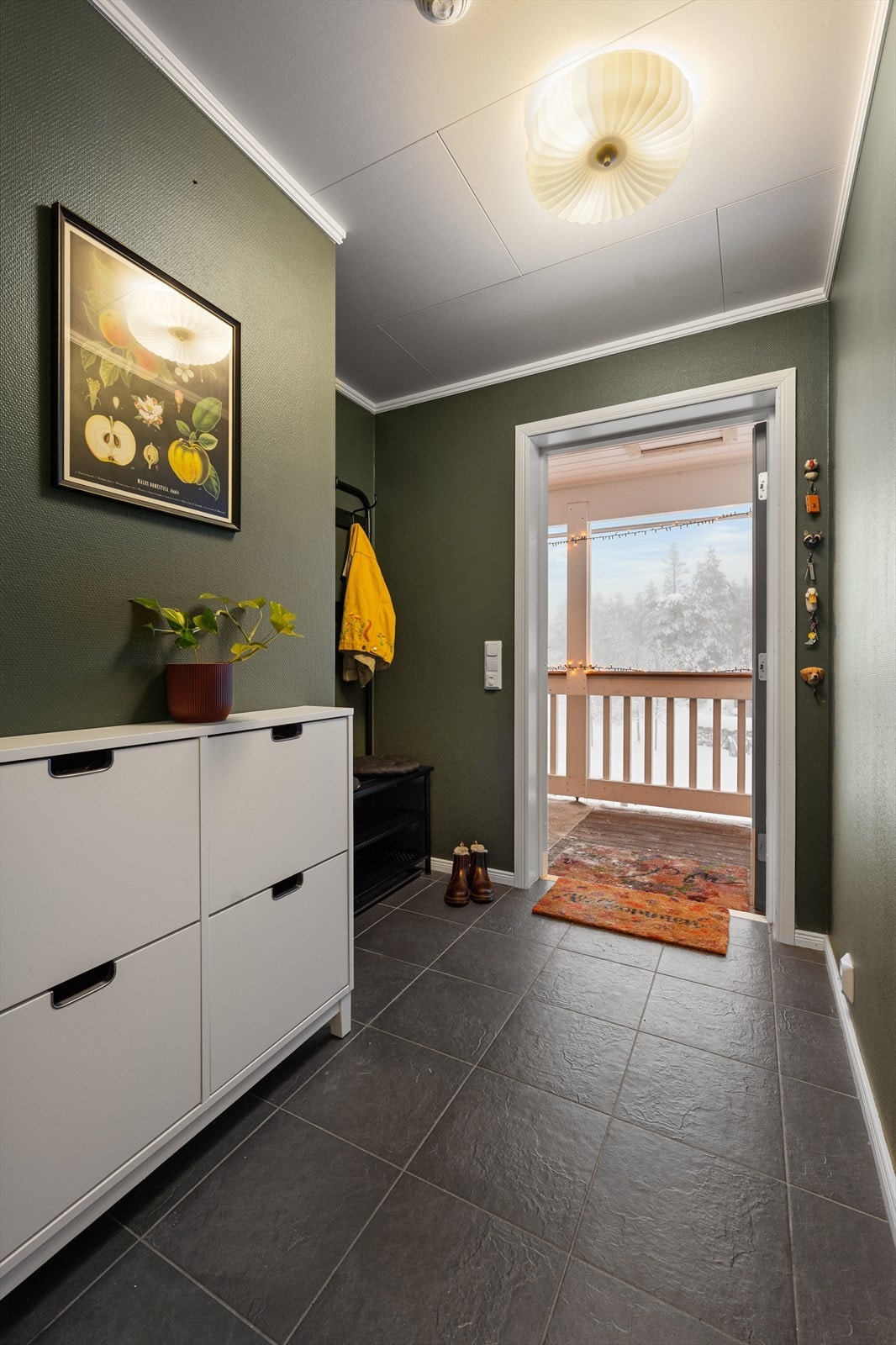 Boligen har adkomst via utvendig trapp til en praktisk entré. Her er det lagt mørke fliser på gulv med behagelig gulvvarme. Galleribilde