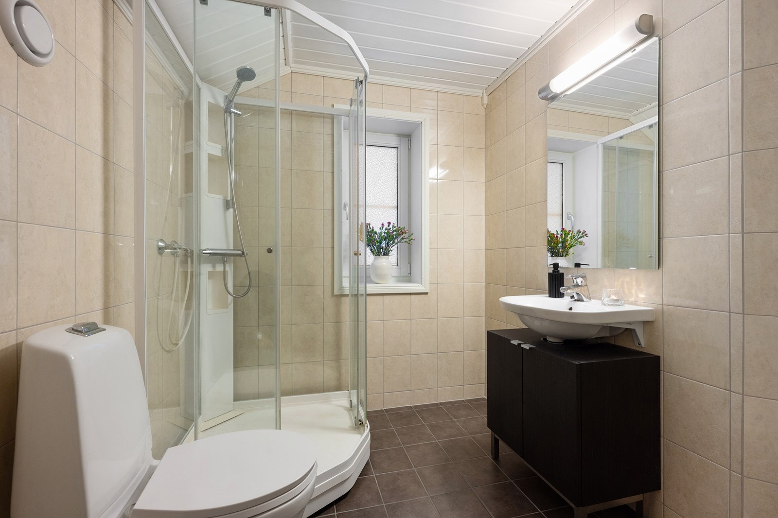 Boligens andre bad ligger i øverste etasje, i tilknytning til loftstue og ett av soverommene. Det er flislagte overflater med varme i gulvet og dusjkabinett. Galleribilde