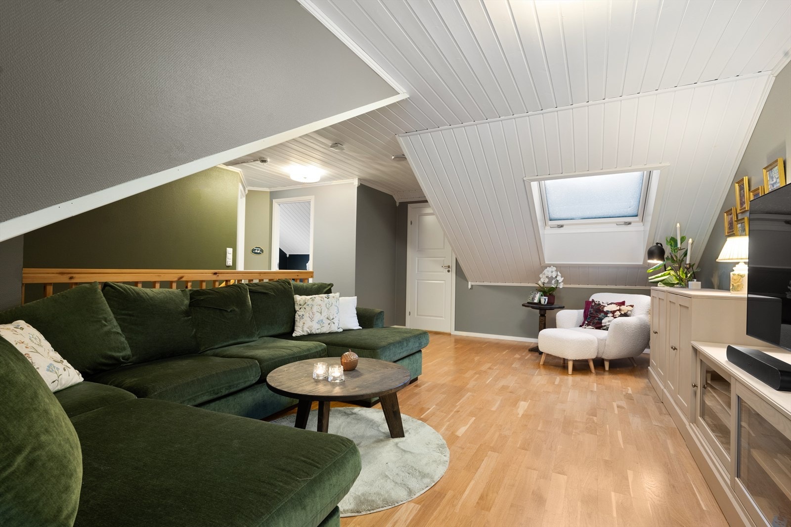 Det er 3-stavs parkett på gulv og malt tapet på vegger. Himlingen er utført med malt panel, som følger rommets skråtak. Galleribilde