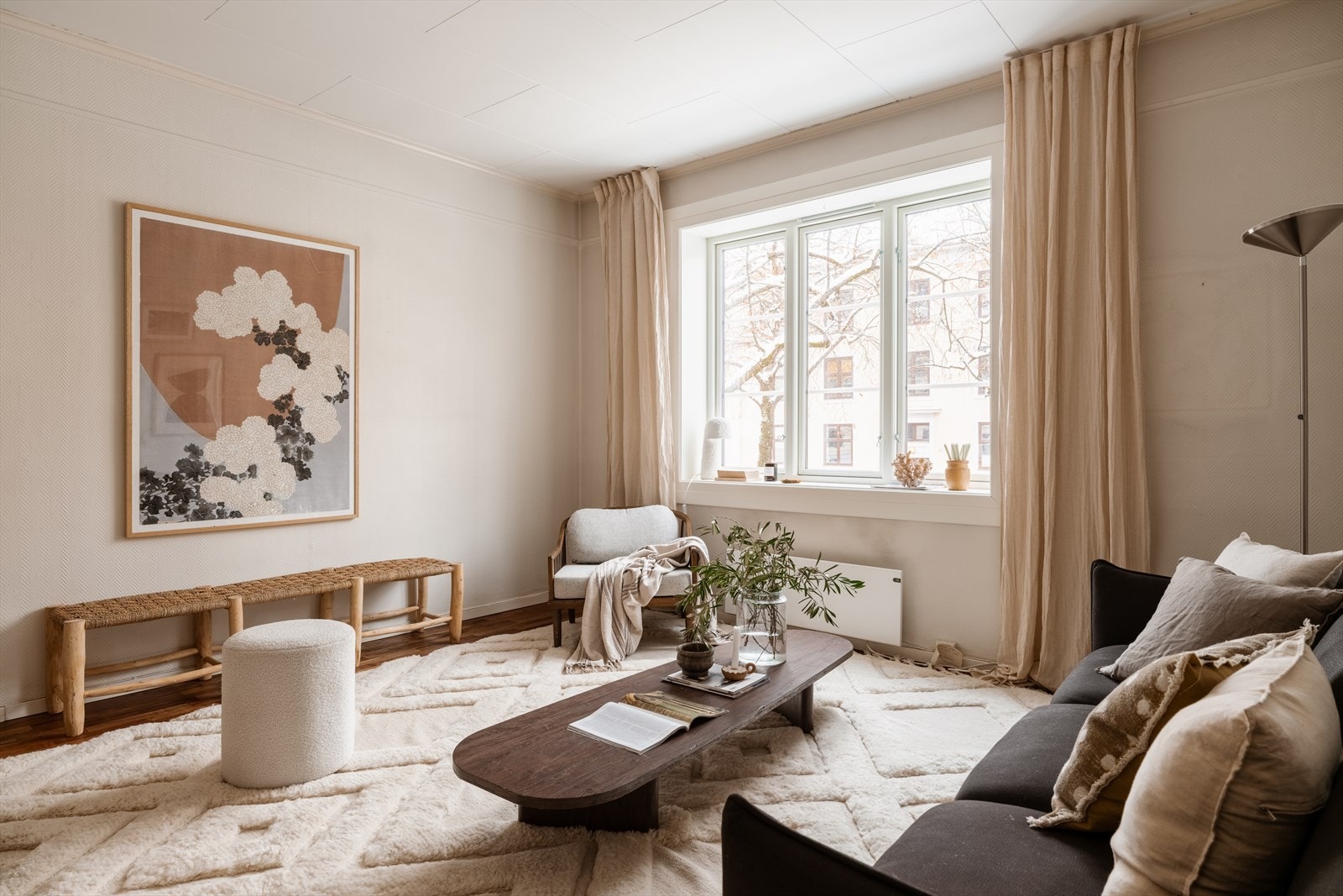 En lys og luftig stue med stort vindu, som gir en luftig atmosfære til rommet. Galleribilde