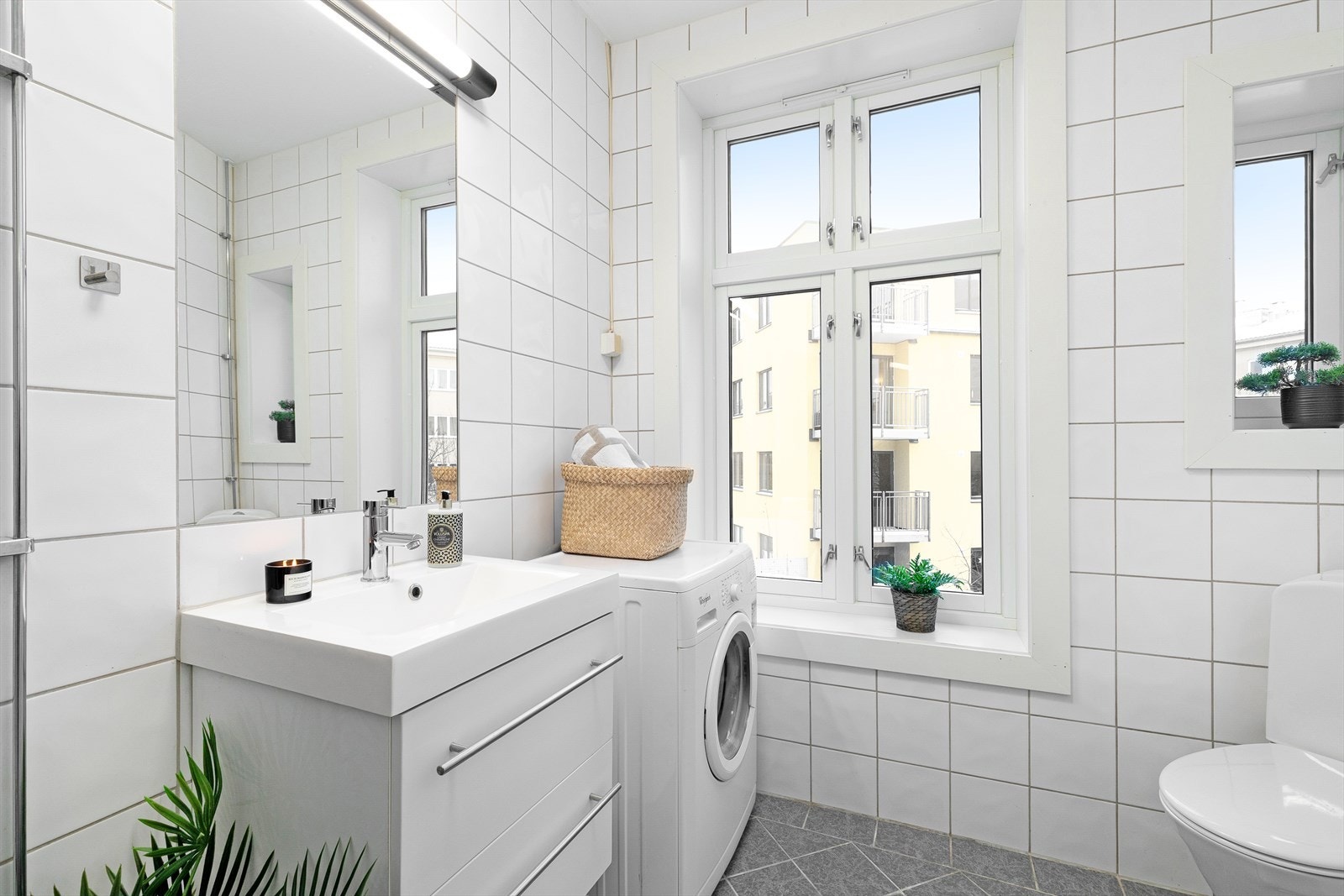 Badet er innredet med servant med underskuffer, dusgjørne med glassdører og gulvmontert toalett. Galleribilde