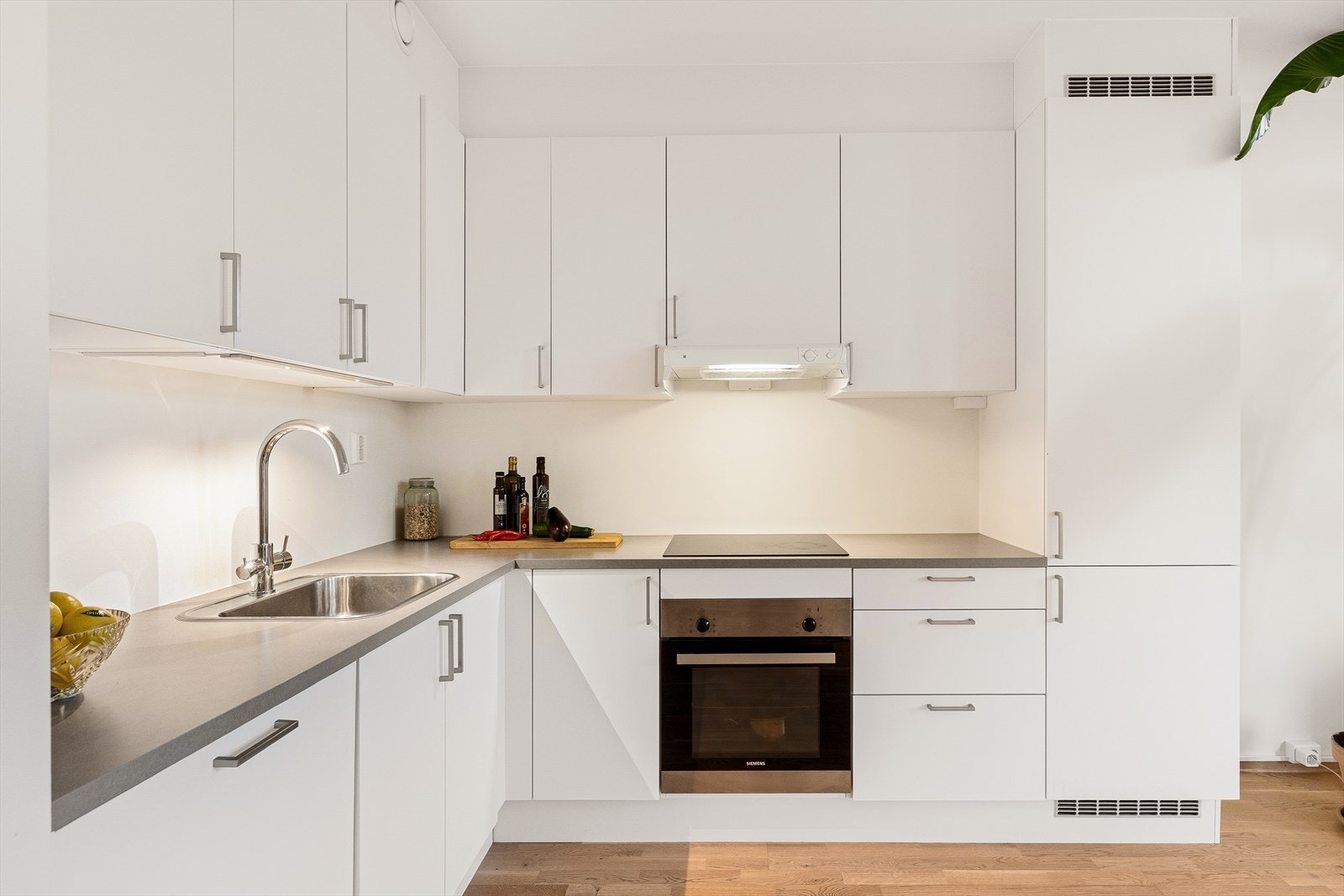 Kjøkkenet kombinerer funksjonalitet og moderne design, og ligger i åpen forbindelse med stuen, noe som skaper en sosial og lys sone perfekt for både matlaging og samvær. Galleribilde