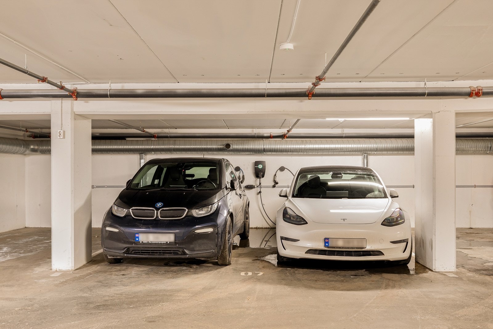 Leiligheten disponerer en romslig parkeringsplass i felles parkeringskjeller, tilrettelagt med elbillader og heisadkomst direkte til leilighetsplanet. Parkeringsplassen er ekstra stor og gir god plass til to biler. Galleribilde