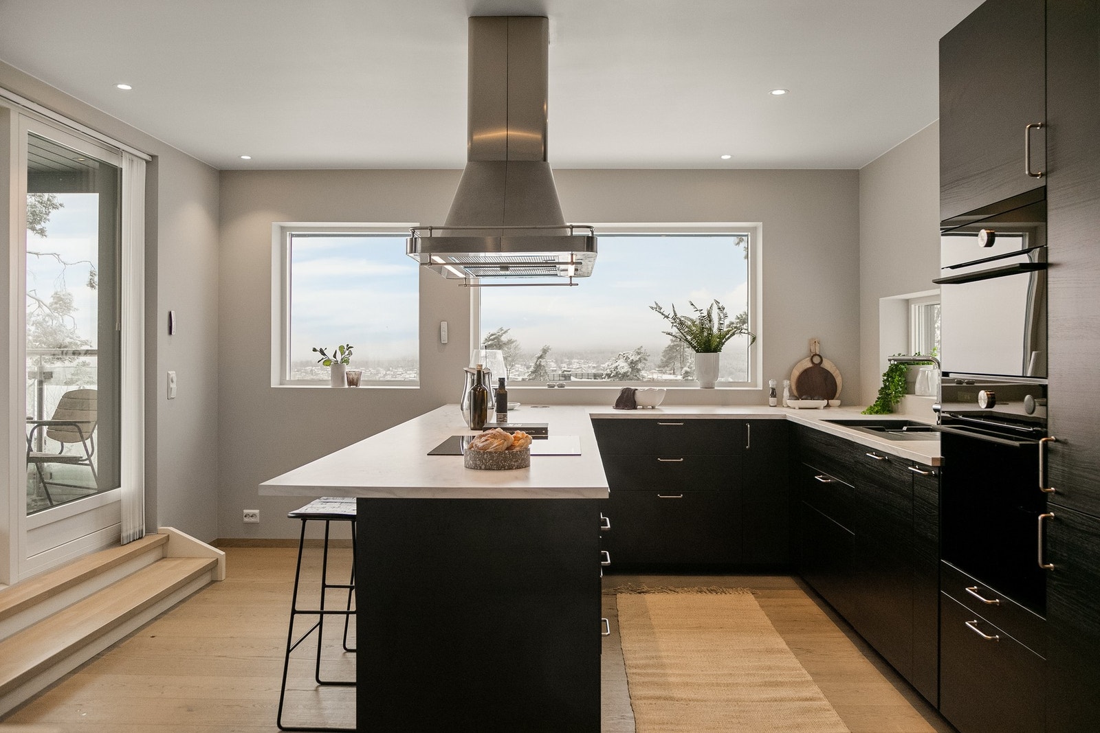 Kjøkkeninnredningen har mørke, glatte fronter og laminatbenkeplate med nedfelt kum i svartfarget kompositt Galleribilde