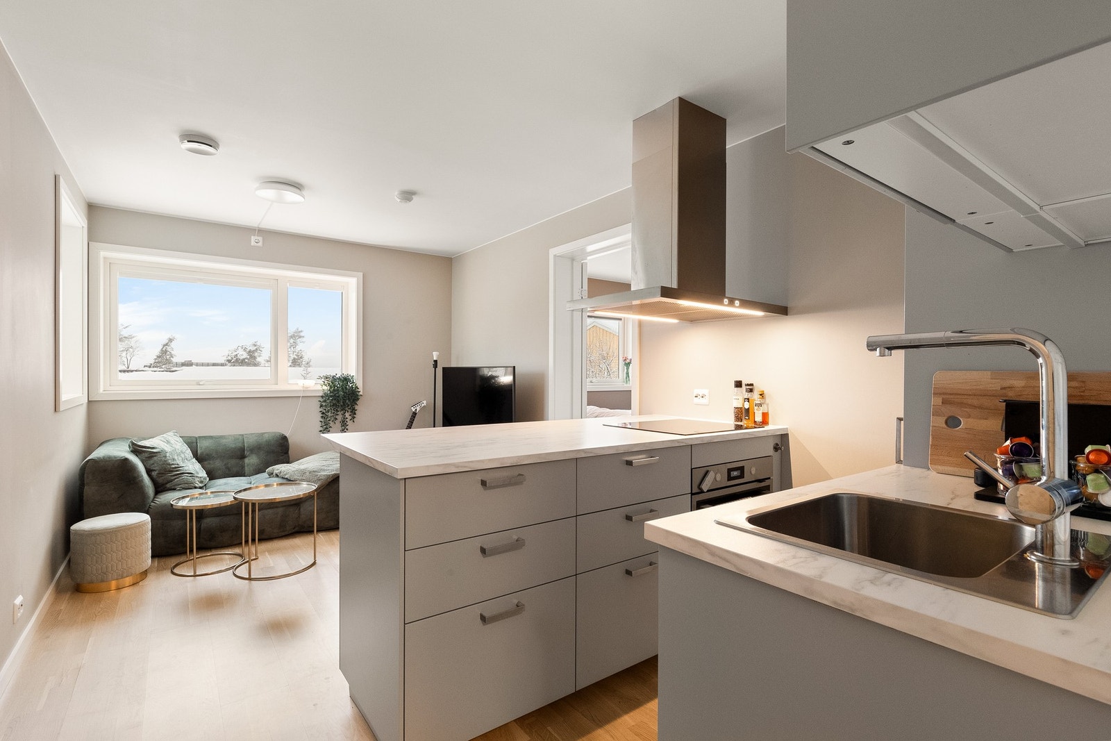 Smart og åpen stue-og kjøkkenløsning med vinduer i to himmelretninger som gir godt med naturlig lys Galleribilde