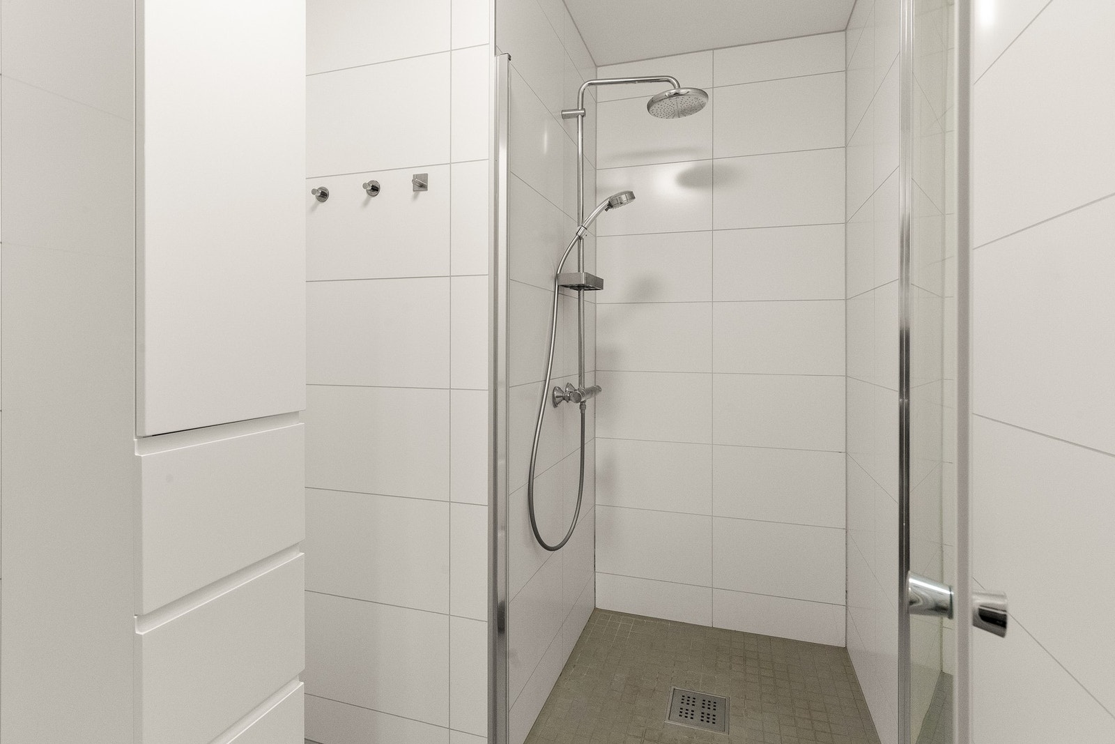 Rommet har nedsenket dusjhjørne med svingdører av herdet glass, regnfallsdusj og termostatstyrt blandebatteri Galleribilde