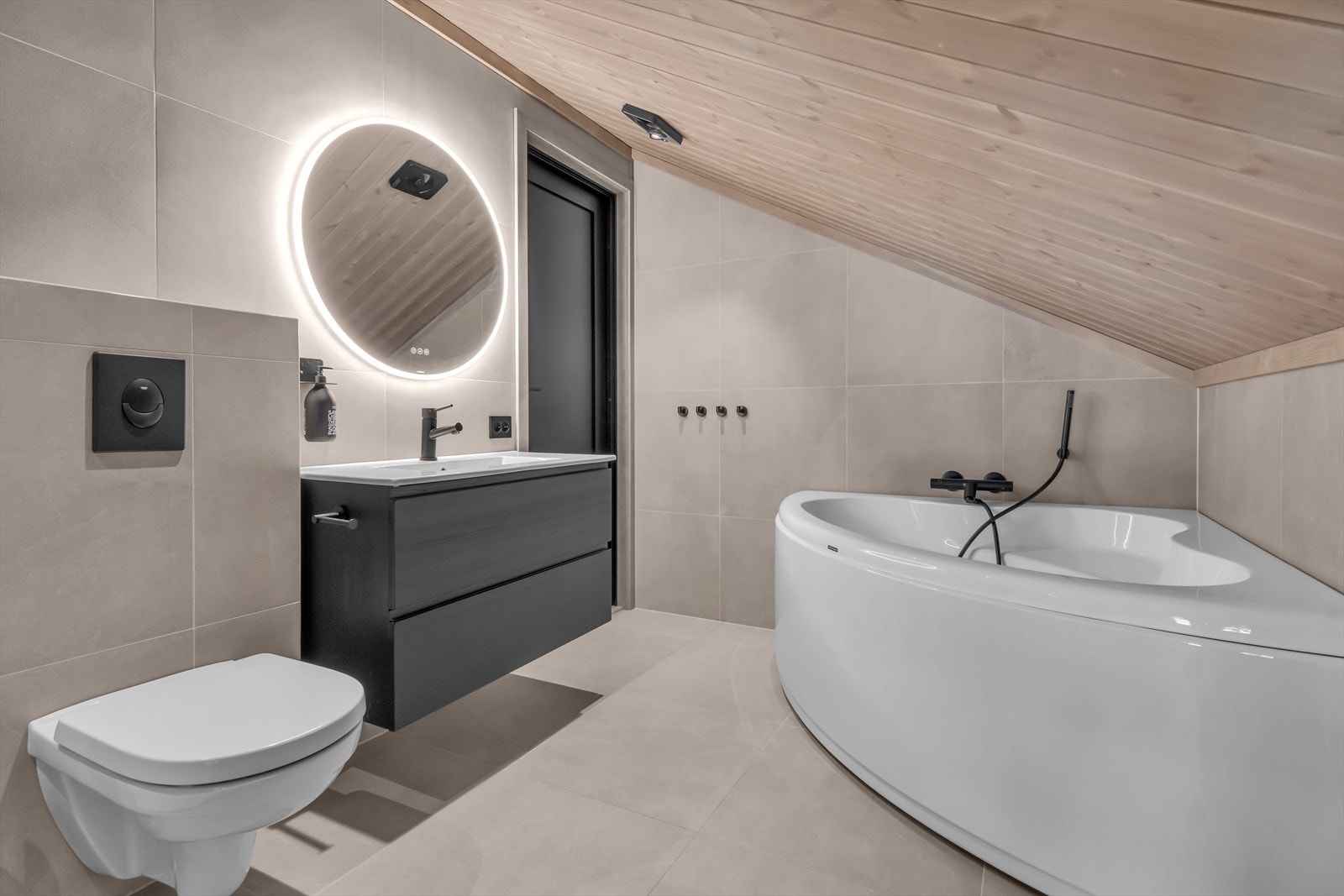 Vakker sort baderomsinnredning, badekar, toalett og dusjhjørne. Galleribilde