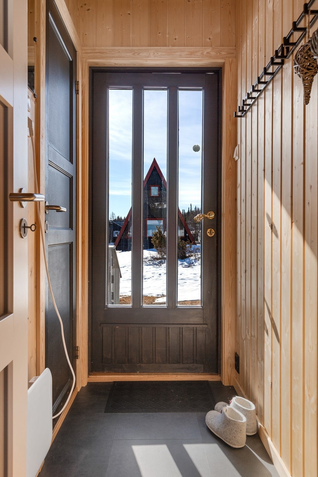 Fra det overbygde inngangspartiet kommer du inn i praktisk entré med plass til yttertøy og sko. Galleribilde