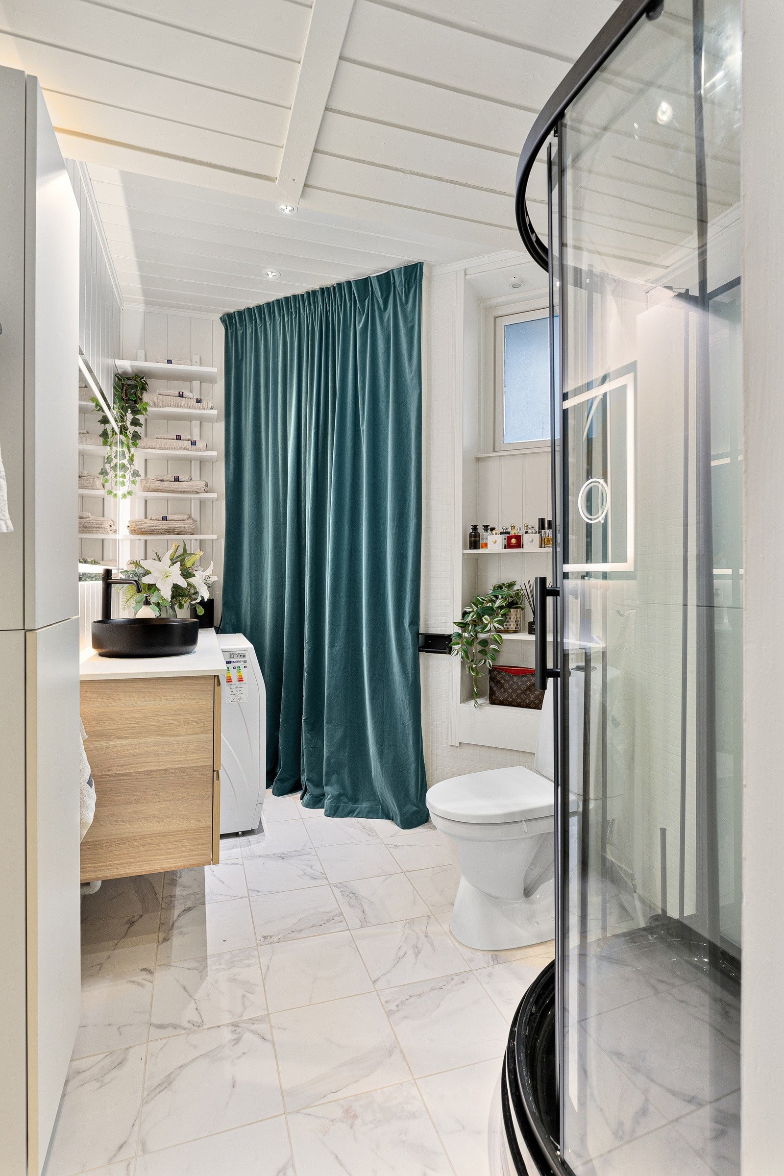 Baderom utstyrt med dusjkabinett, gulvstående klosett og bollerservant på skuffeseksjon. Galleribilde