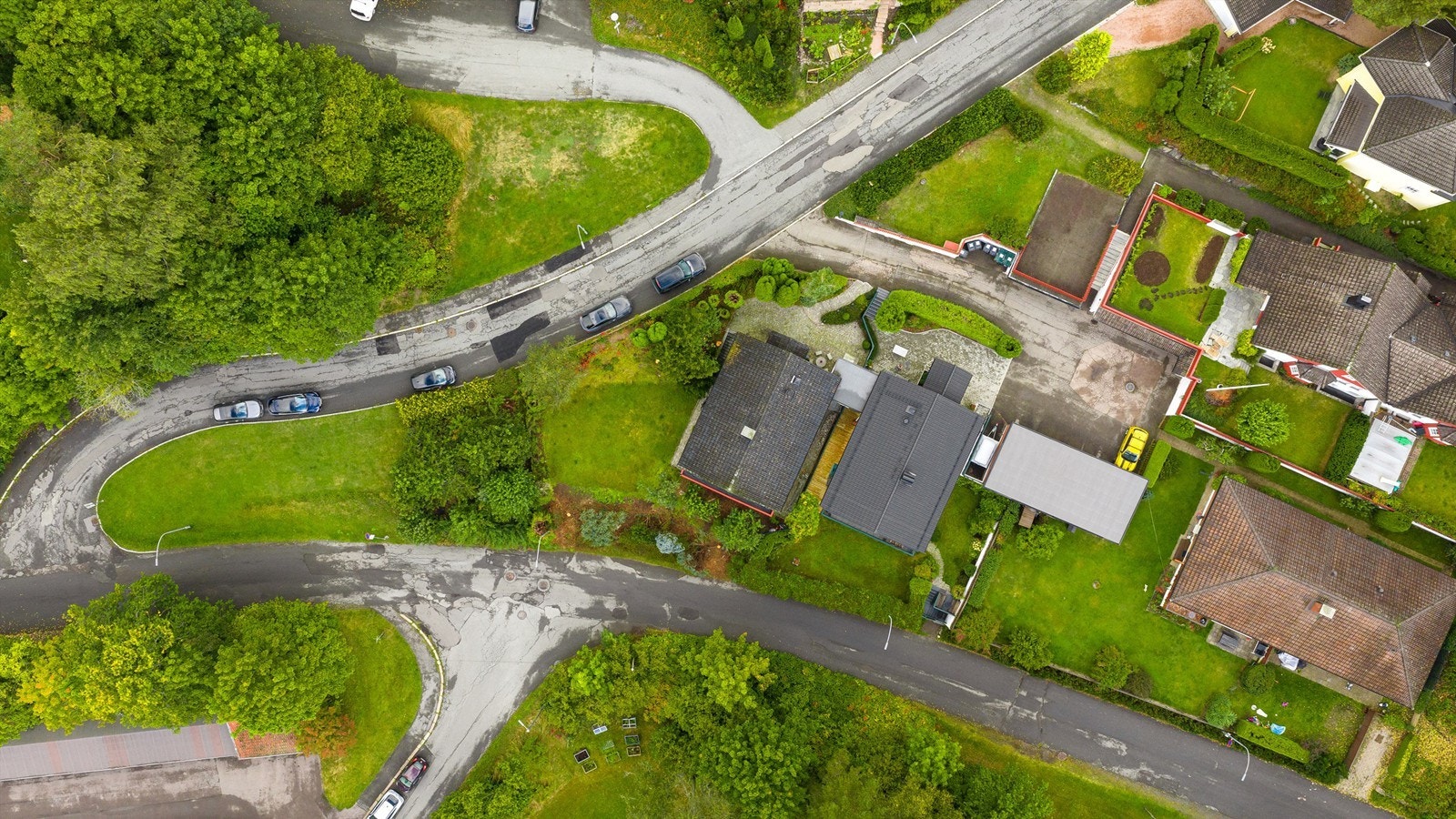 Eiendommen ligger stille og solrikt med gode og romslige arealer. Hageparsell mot fellesareal/plen, med frukttrær. Her ser en også tydelig nye takkledninger på boligen og rekkegarasjen. Tilhenger er plassert mellom garasjen og boligen. Galleribilde