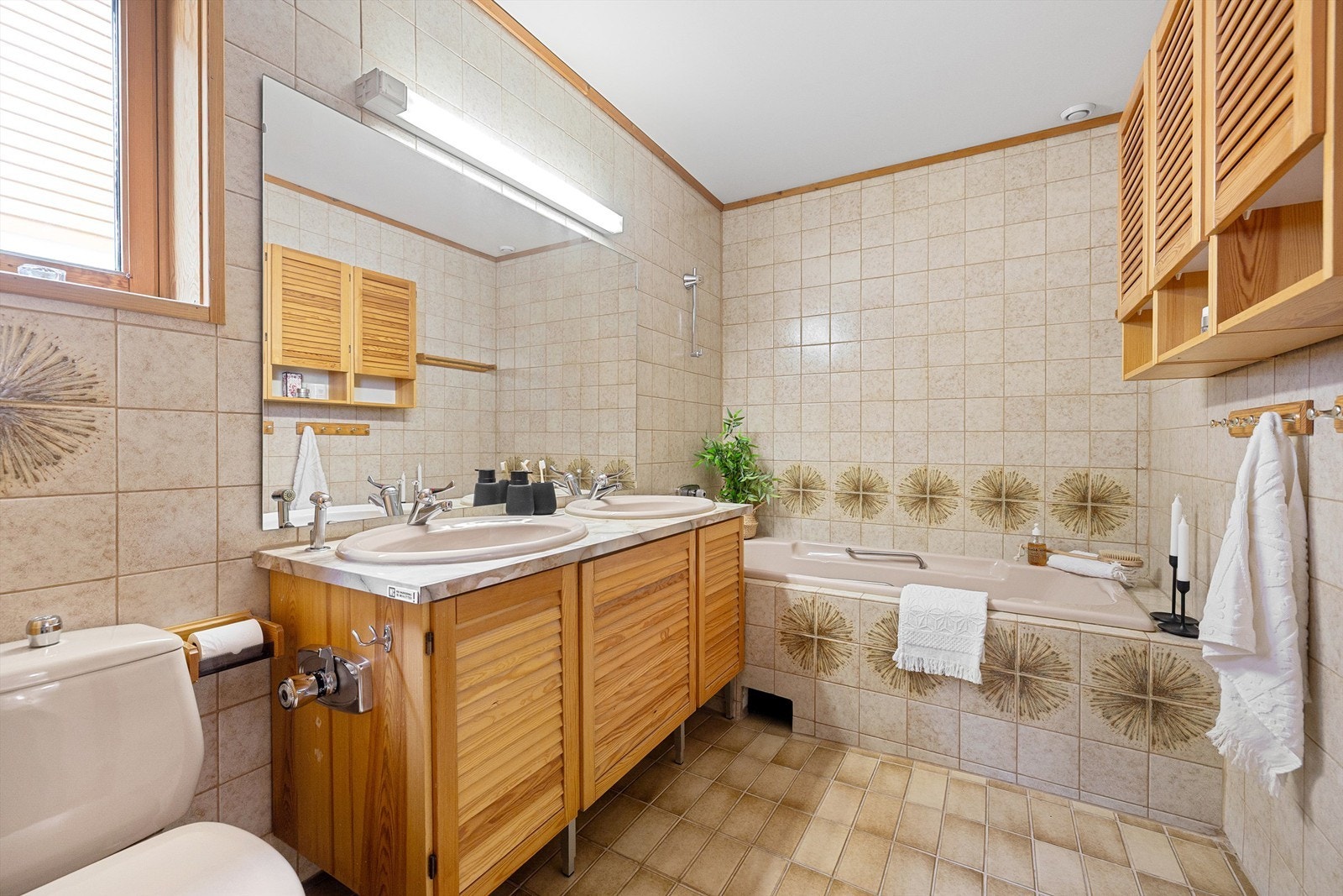 Romslig flislagt baderom med gullvarme og romslig badekar i glassfiber. 1,7 m langt og ekstra bredde med innfelte håndtak Galleribilde