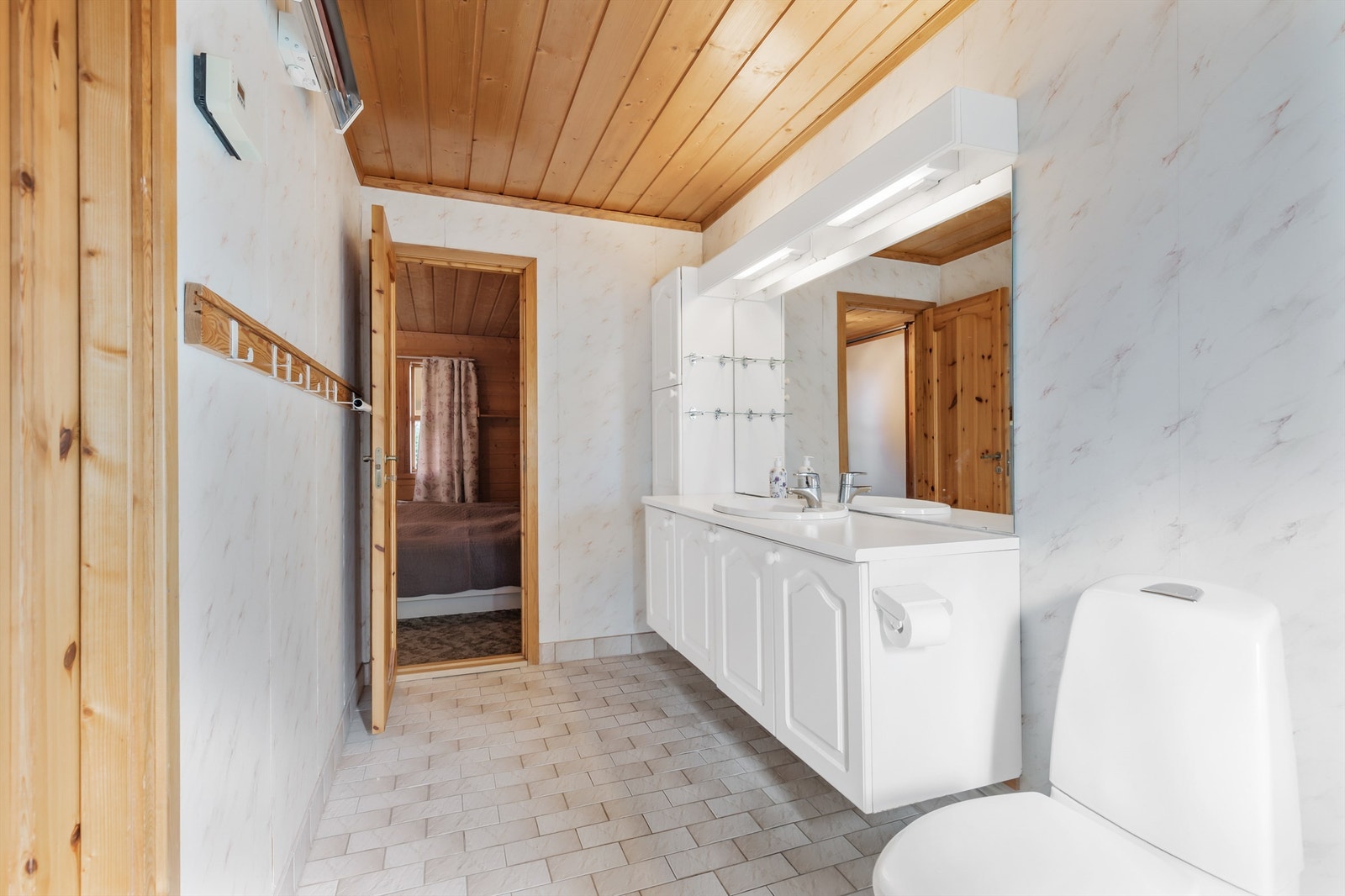 Flislagt gulv med varmekabler (varmekabler er frakoblet og fungerer ikke). Veggflater med tapet og fliser i dusjsonen. Himling med panel. Galleribilde