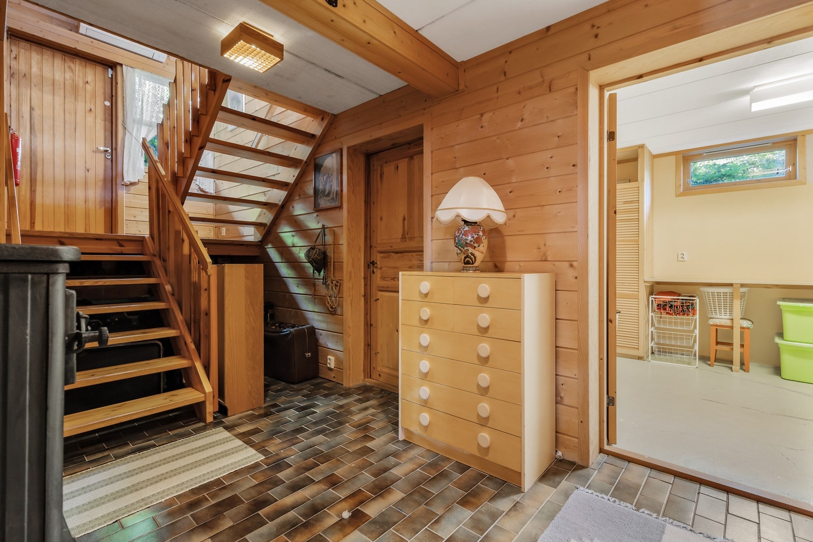 I kjelleren kommer man ned til en gang, med adkomst til kjellerstue, kjølerom, vaskerom og boder Galleribilde