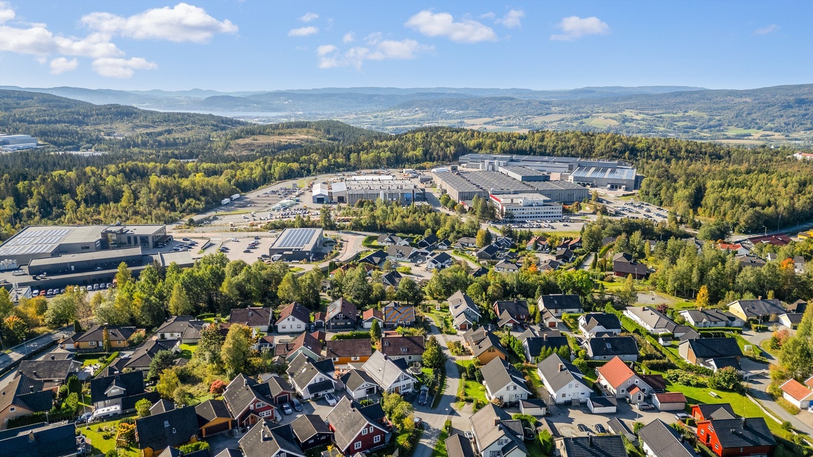 Etablert boligfelt med utsikt mot skogkledde åser. Galleribilde