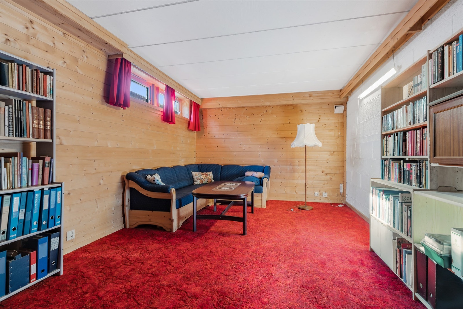 Oppholdsrom med panelvegger og teppegulv. Galleribilde