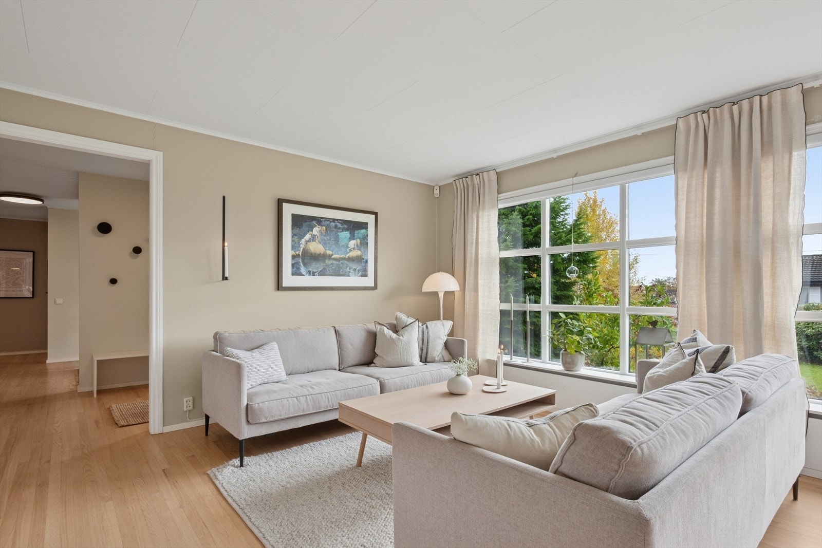 Stuen har store vindusflater som slipper inn rikelig med naturlig lys og skaper en luftig og lett atmosfære i hele oppholdsrommet. Galleribilde