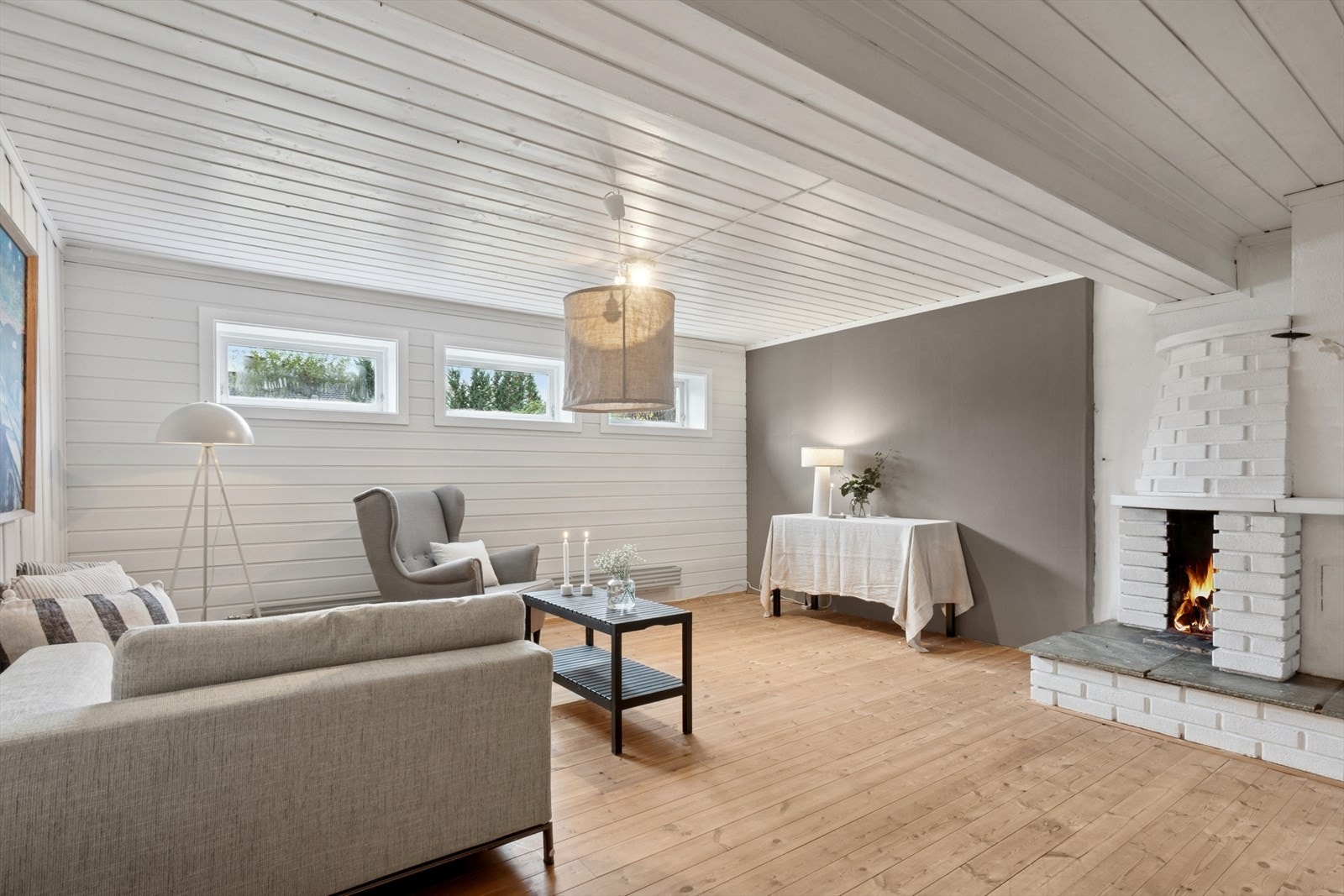 Kjellerstuen har god størrelse og gir fleksible innredningsmuligheter. Den åpne peisløsningen fungerer som et naturlig blikkfang og tilfører rommet både karakter og varme. Galleribilde