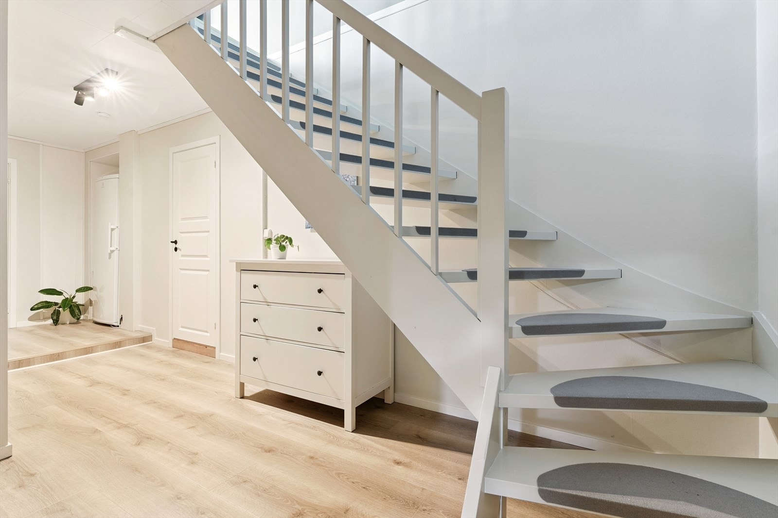 Gang med entré i underetasjen er lys og trivelig. Laminat på golv og malte plater på vegg. Galleribilde