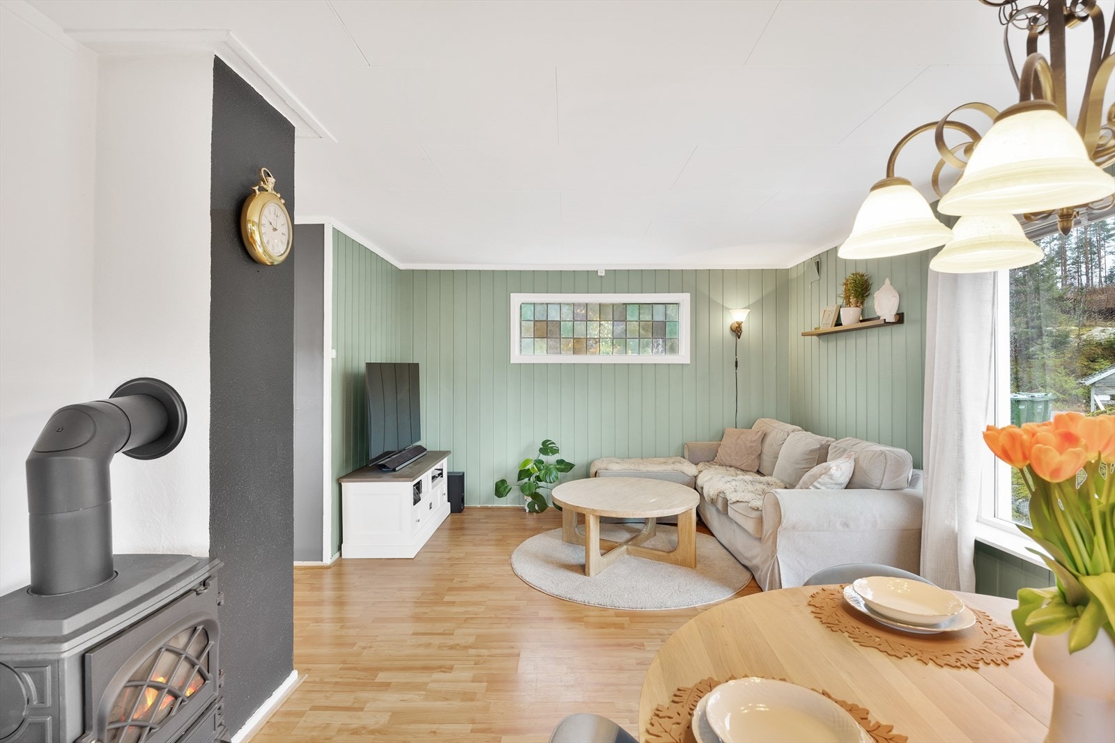 Rommet har grønnmalte vegger mot gyllent laminatgulv. Galleribilde