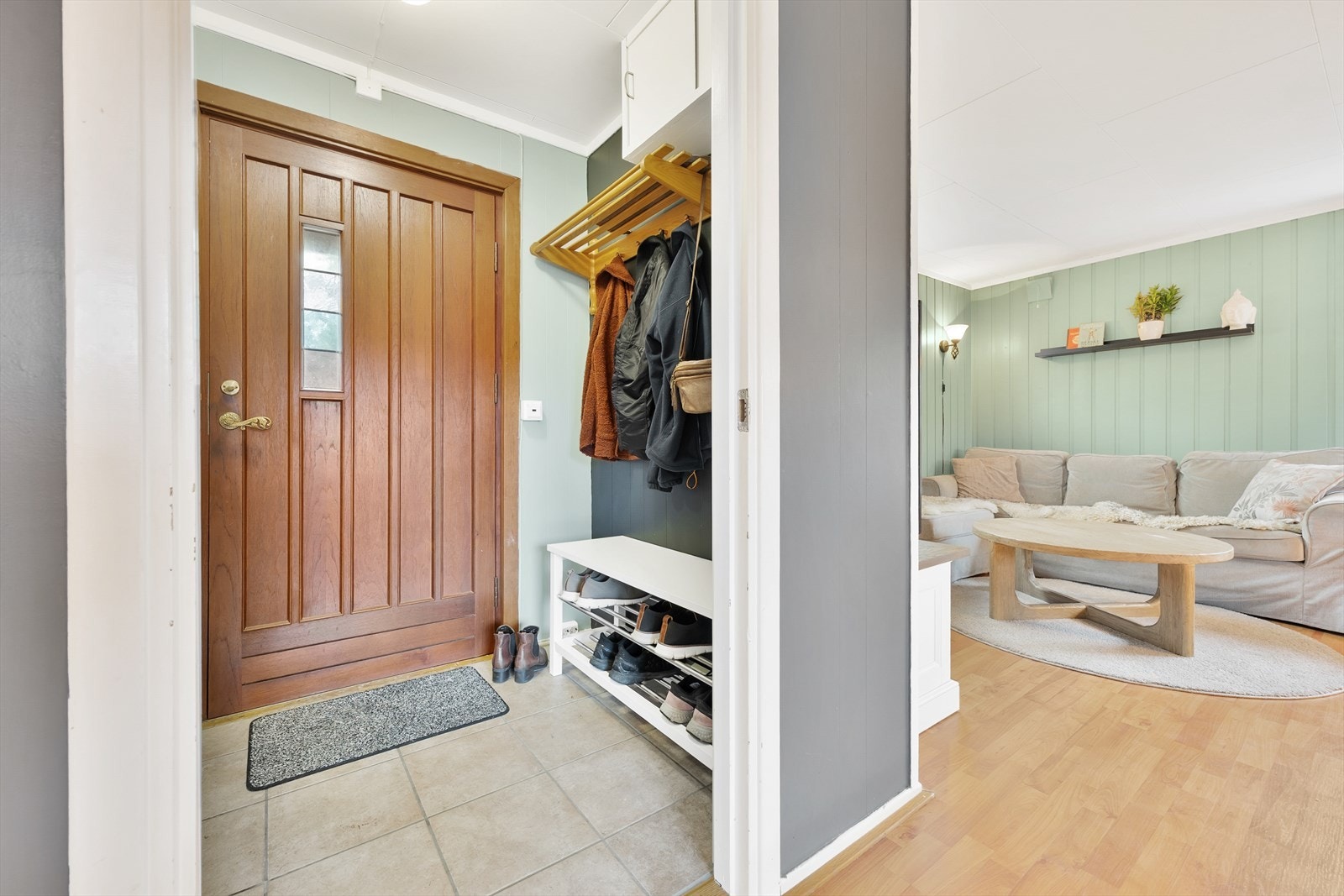 Entréen har malte vegger og fliser på gulv med lun varme under. For oppheng av ytterklær og sko er det etablert åpen garderobeløsning med hylle/knaggrekke og skohylle. Galleribilde