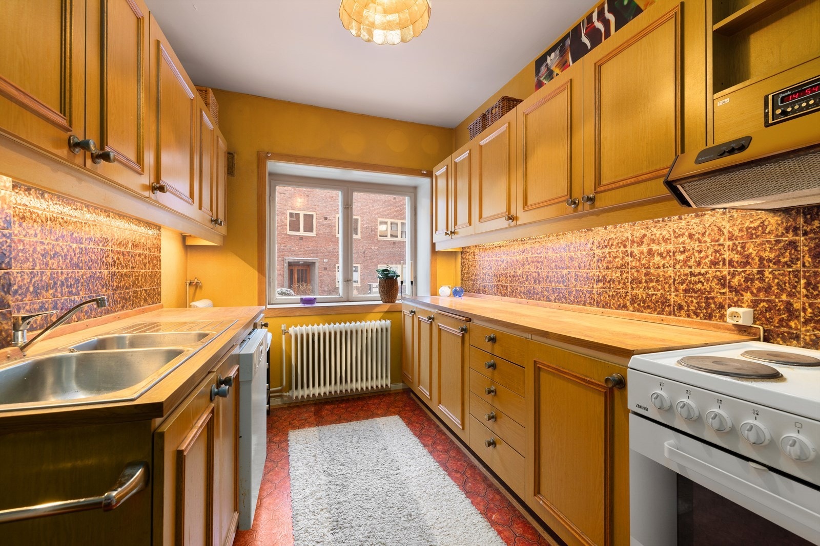 Kjøkkenet er innredet med profilerte fronter og laminat benkeplate, antatt fra ca. 1980. Galleribilde