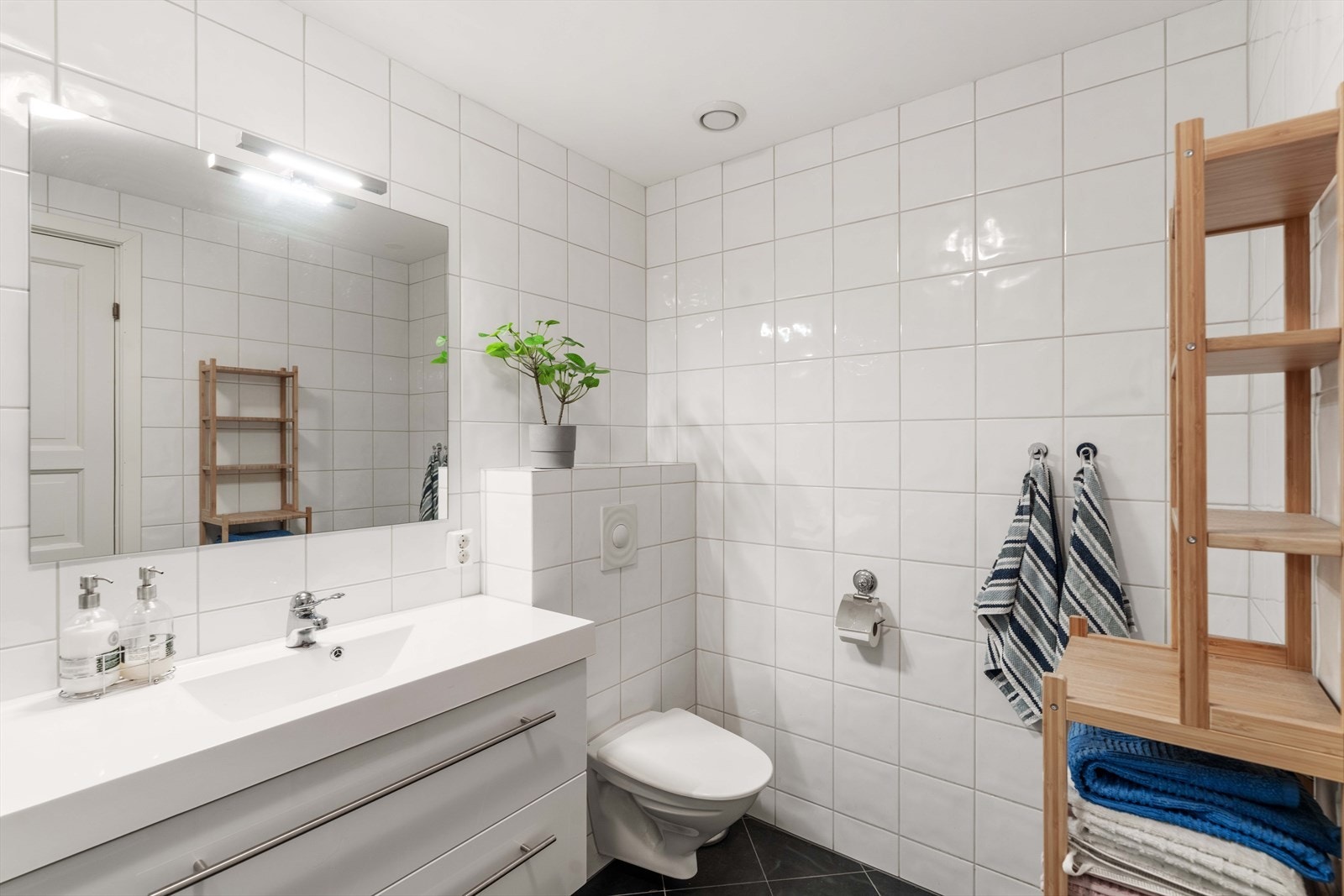 Pent, helfliset bad med vegghengt toalett, dusjnisje og baderomsinnredning. Galleribilde