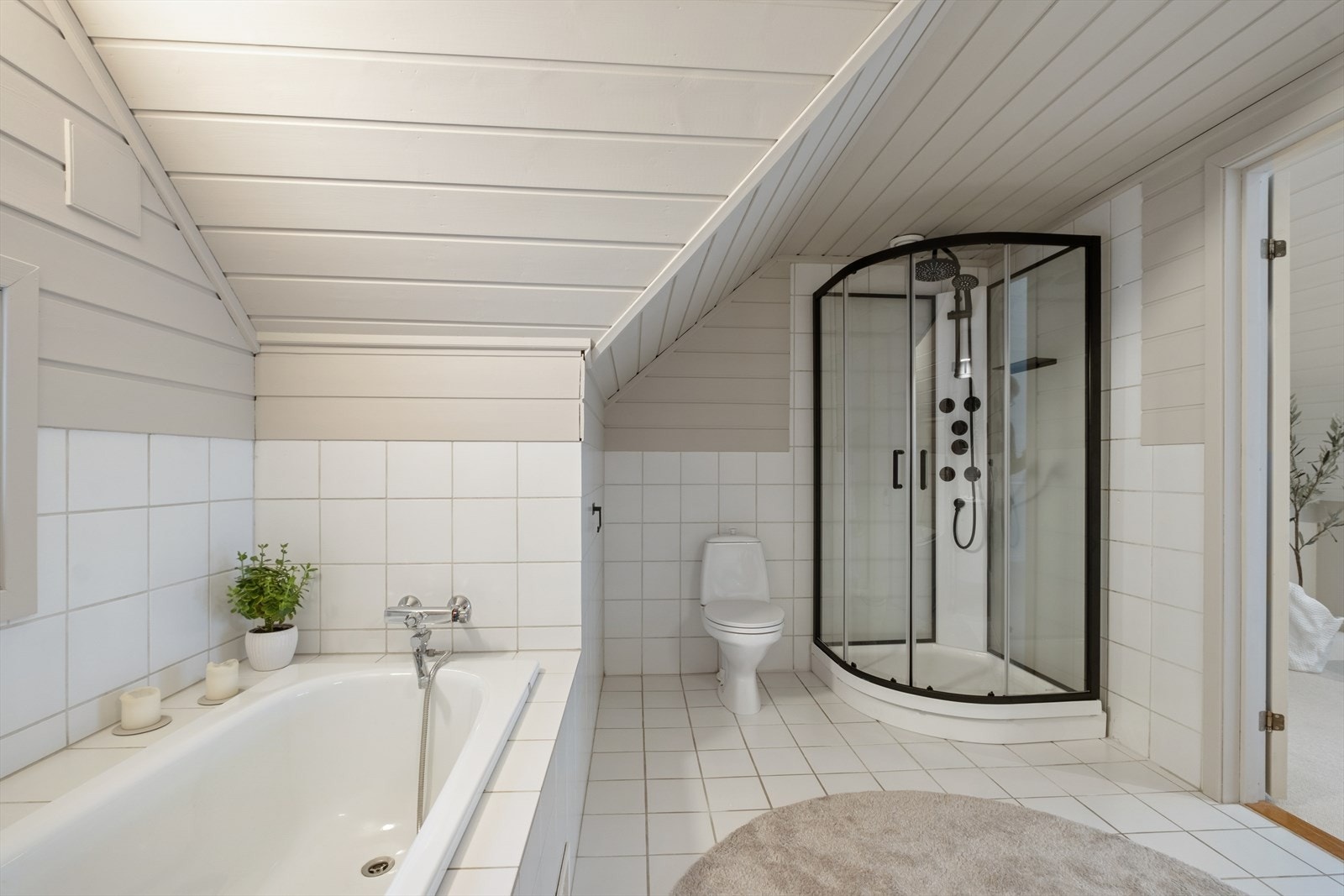 Rommet er utstyrt med en baderomsinnredning med dobbel servant, et gulvstående toalett, dusjkabinett og badekar. Galleribilde