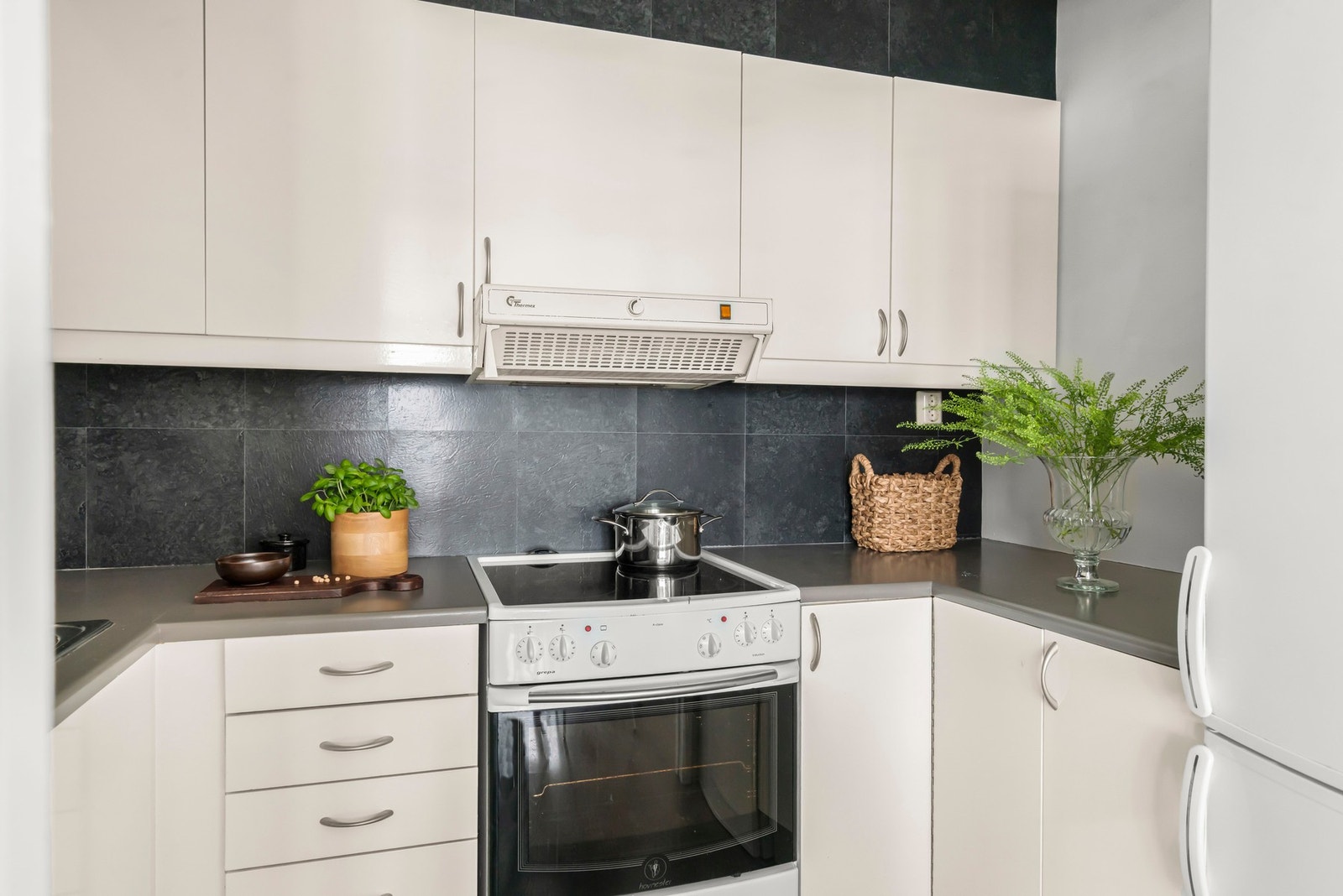 Kjøkkenet har glatte fronter, laminerte benkeplater og nedfelt oppvaskkum i børstet rustfritt stål. Galleribilde