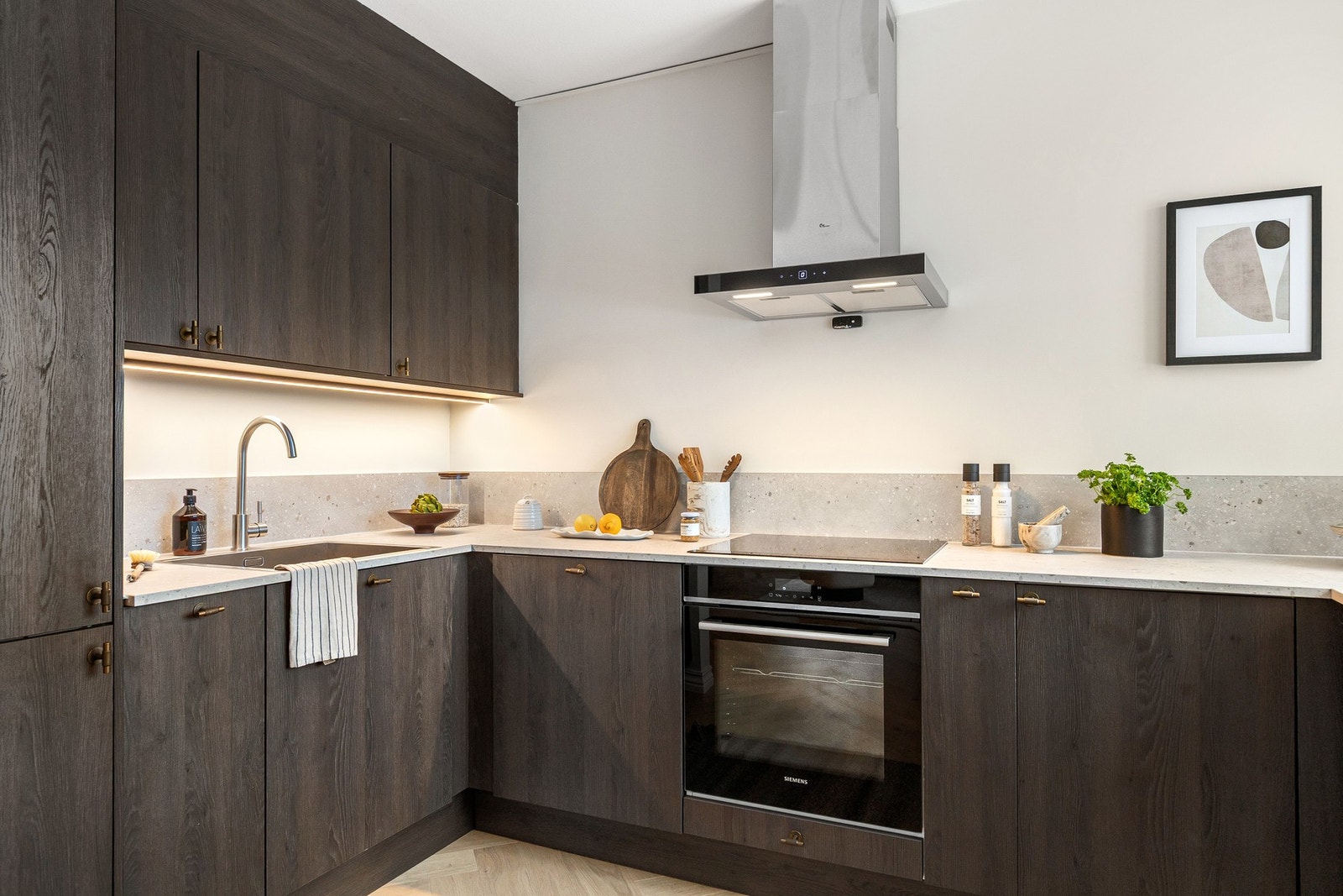 Det er benkeplate av slitesterk laminat, benkeskapsbelysning samt praktiske stikkontakter under overskapene. Galleribilde