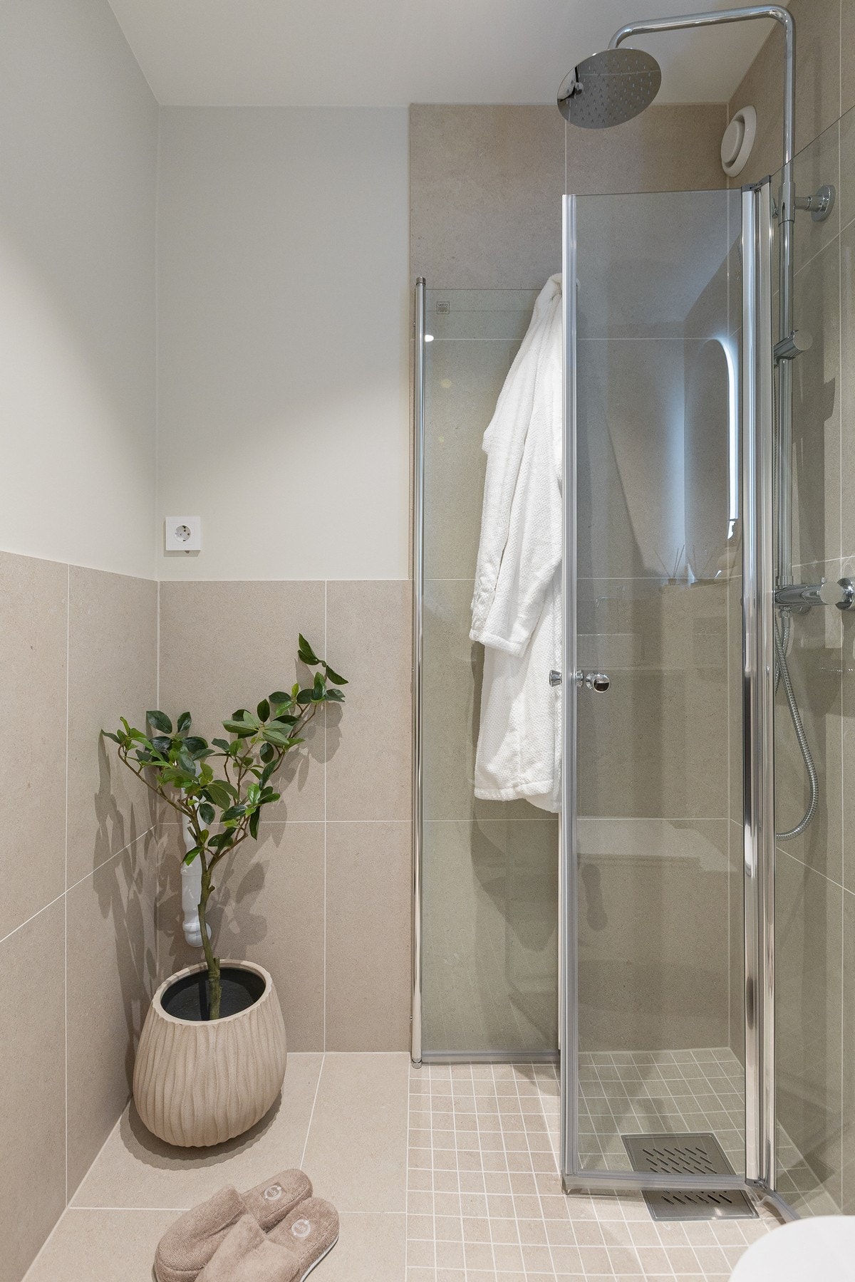 Dusjløsning i hjørne med innfellbare glassdører og både tak- og hånddusj. Det er også opplegg for vaskemaskin. Galleribilde