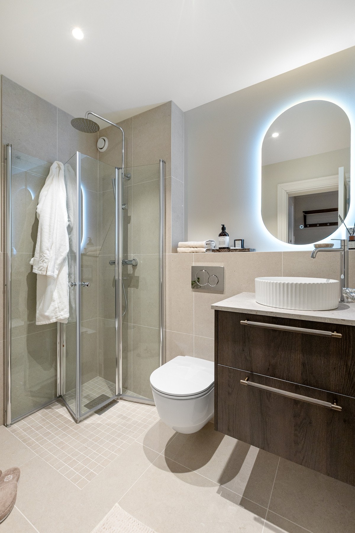 Gulvet er flislagt med behagelig gulvvarme, veggene er flislagt og malt i stilrene farger, og himlingen har slett malt flate med downlights. Galleribilde