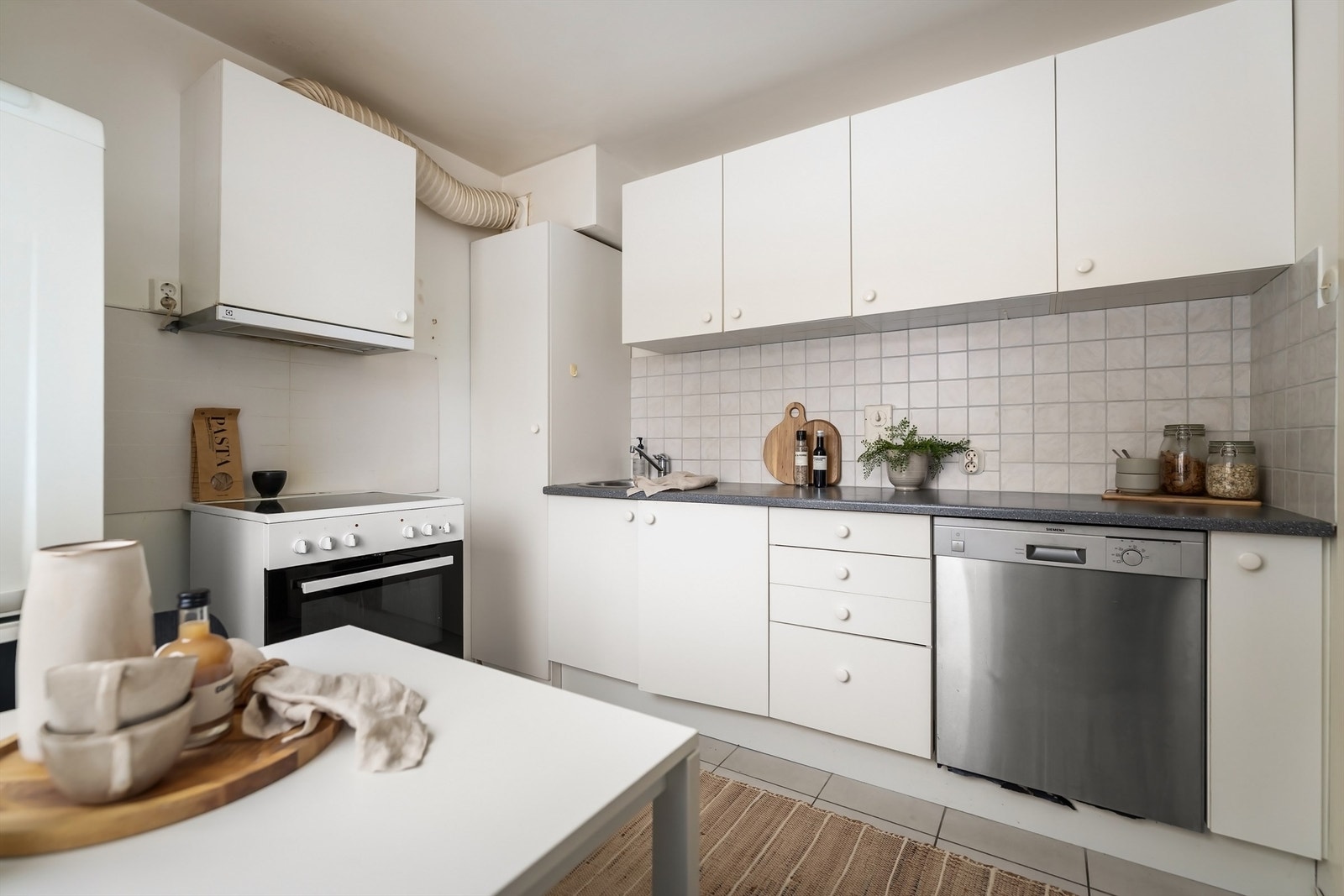 God plass til en romslig kjøkkeninnredning med mye skap- og benkeplass Galleribilde