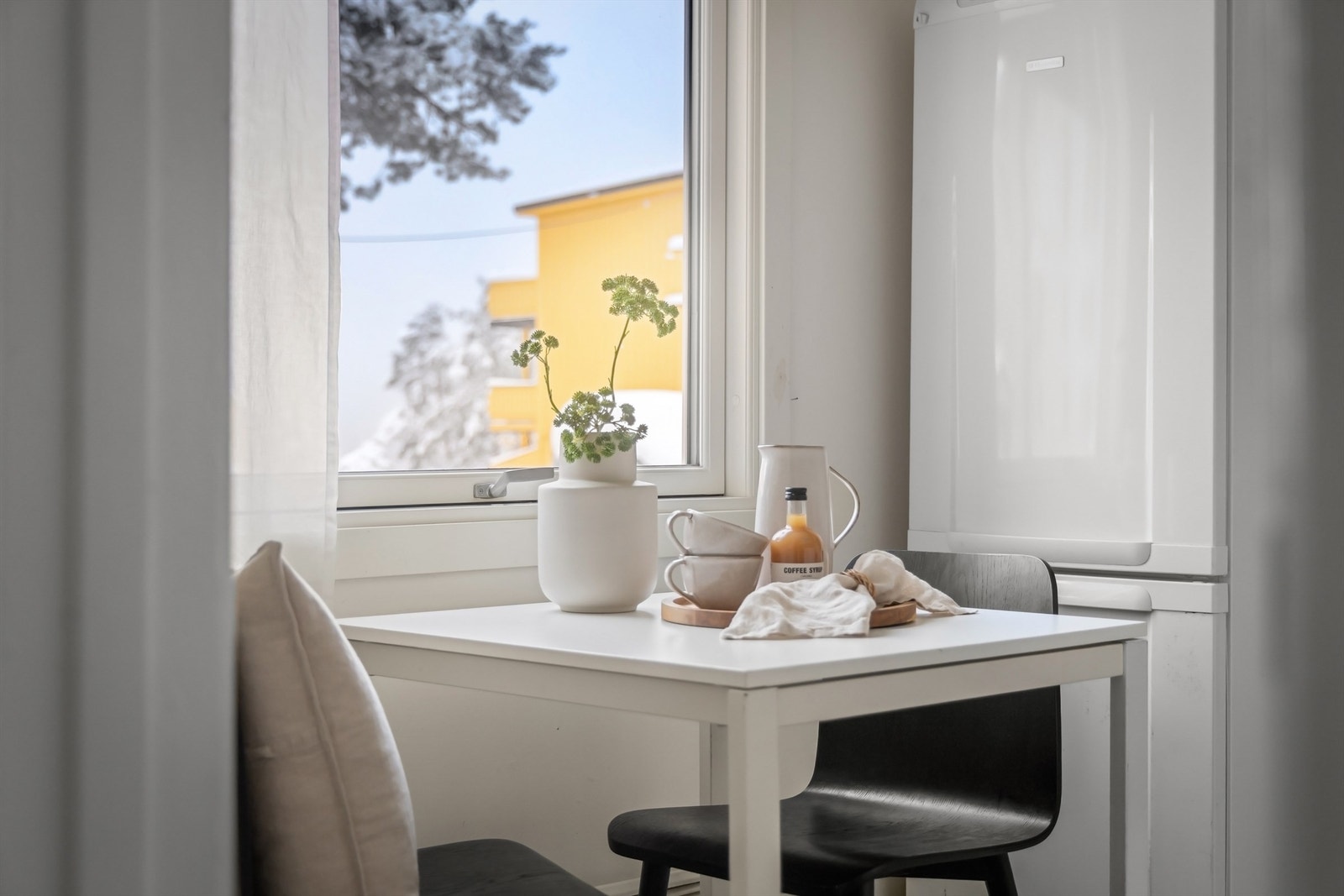 God plass til et hyggelig spisebord under vindu Galleribilde