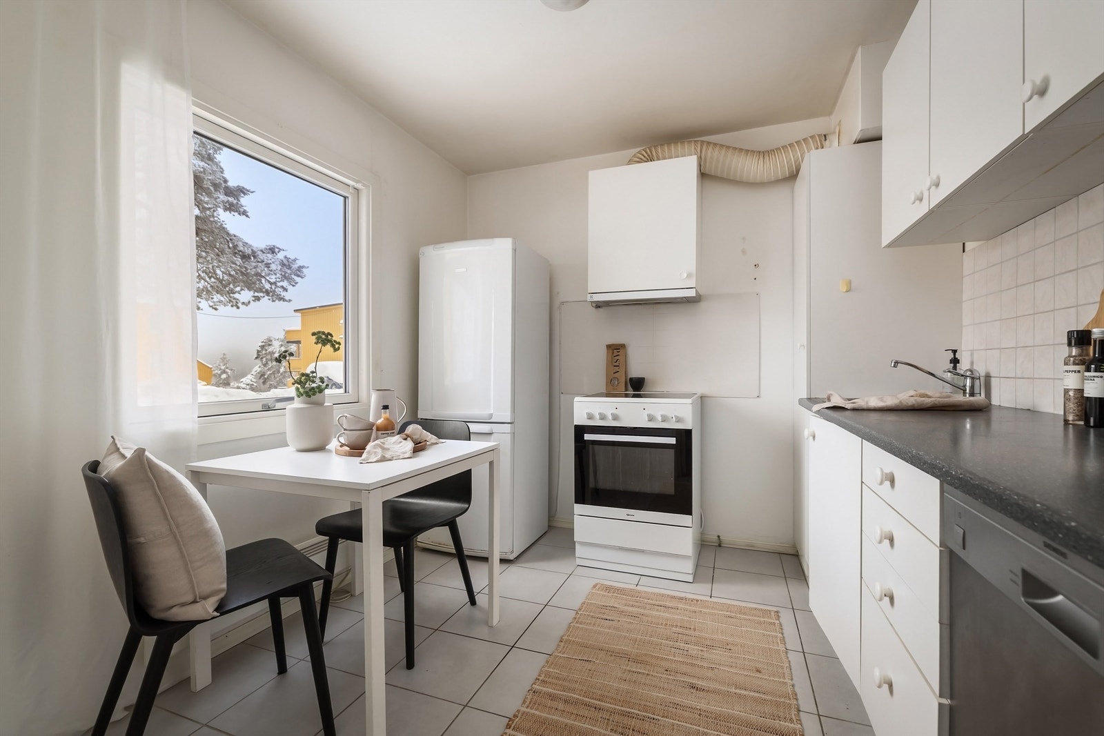 Eldre kjøkkeninnredning med hvite fronter, rustfri oppvaskkum og ettgreps armatur. Behov for oppussing for å tilfredsstille dagens standard Galleribilde