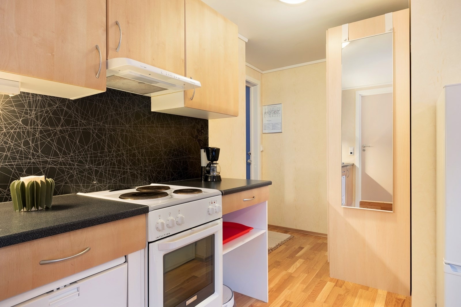 Kjøken med slette frontar og benkeplate av laminat. Kvitevarer er frittståande. Galleribilde