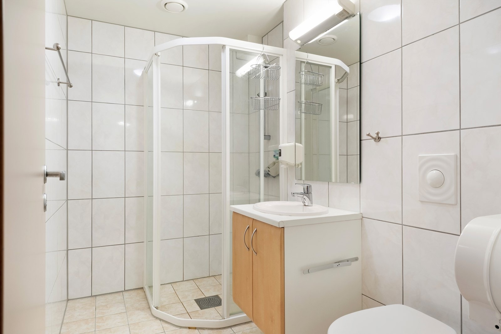 Heilflisa bad innreia med dusjhjørne, servant og toalett. Galleribilde