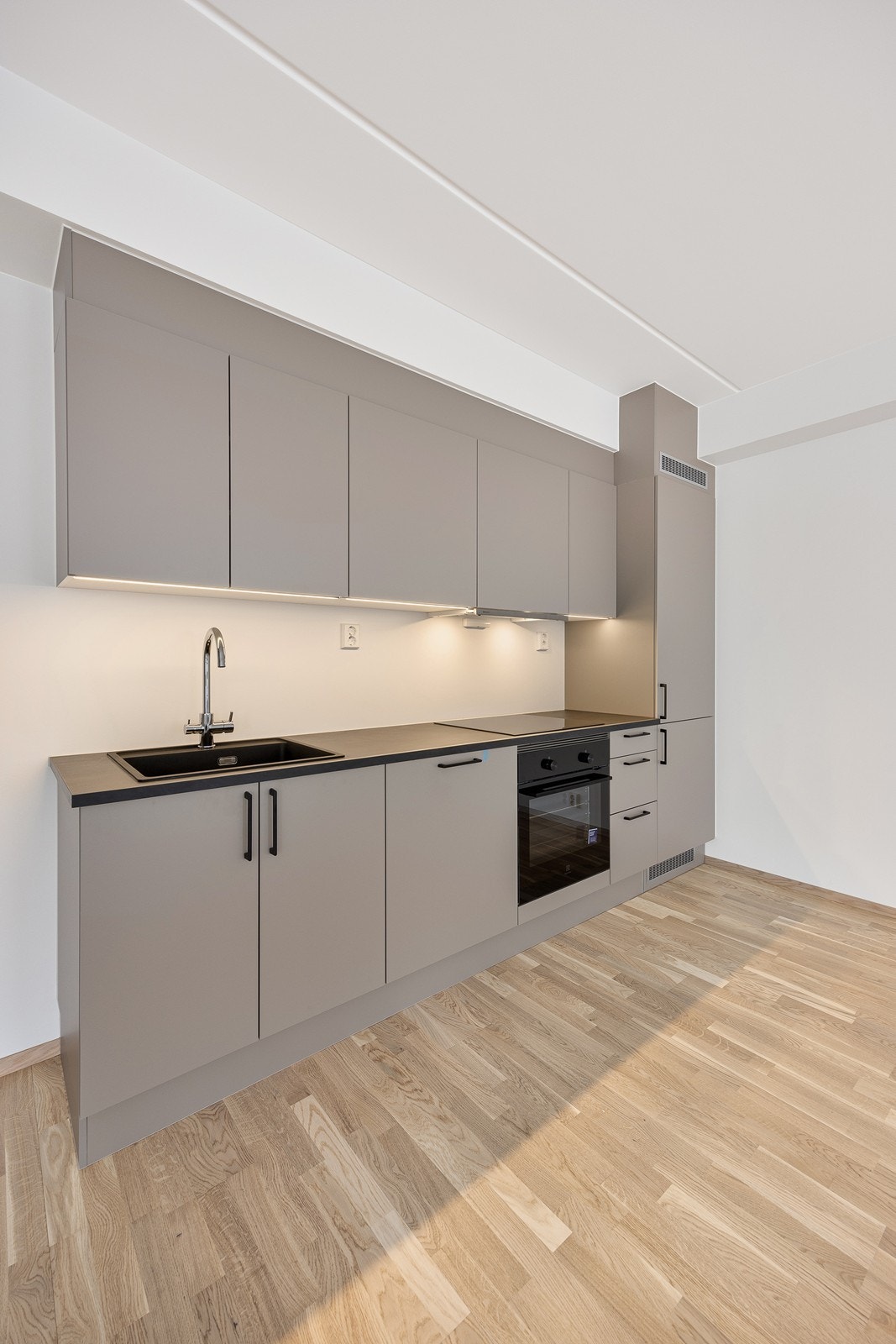 Kjøkkeninnredningen er fra HTH og har et stilrent design med glatte beige fronter og laminat benkeplate. Galleribilde