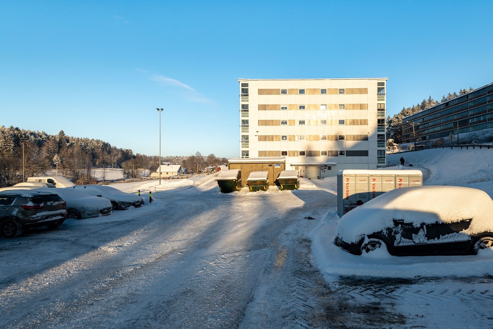 Asfaltert parkeringsområde gir enkel parkering ved boligblokken. Galleribilde