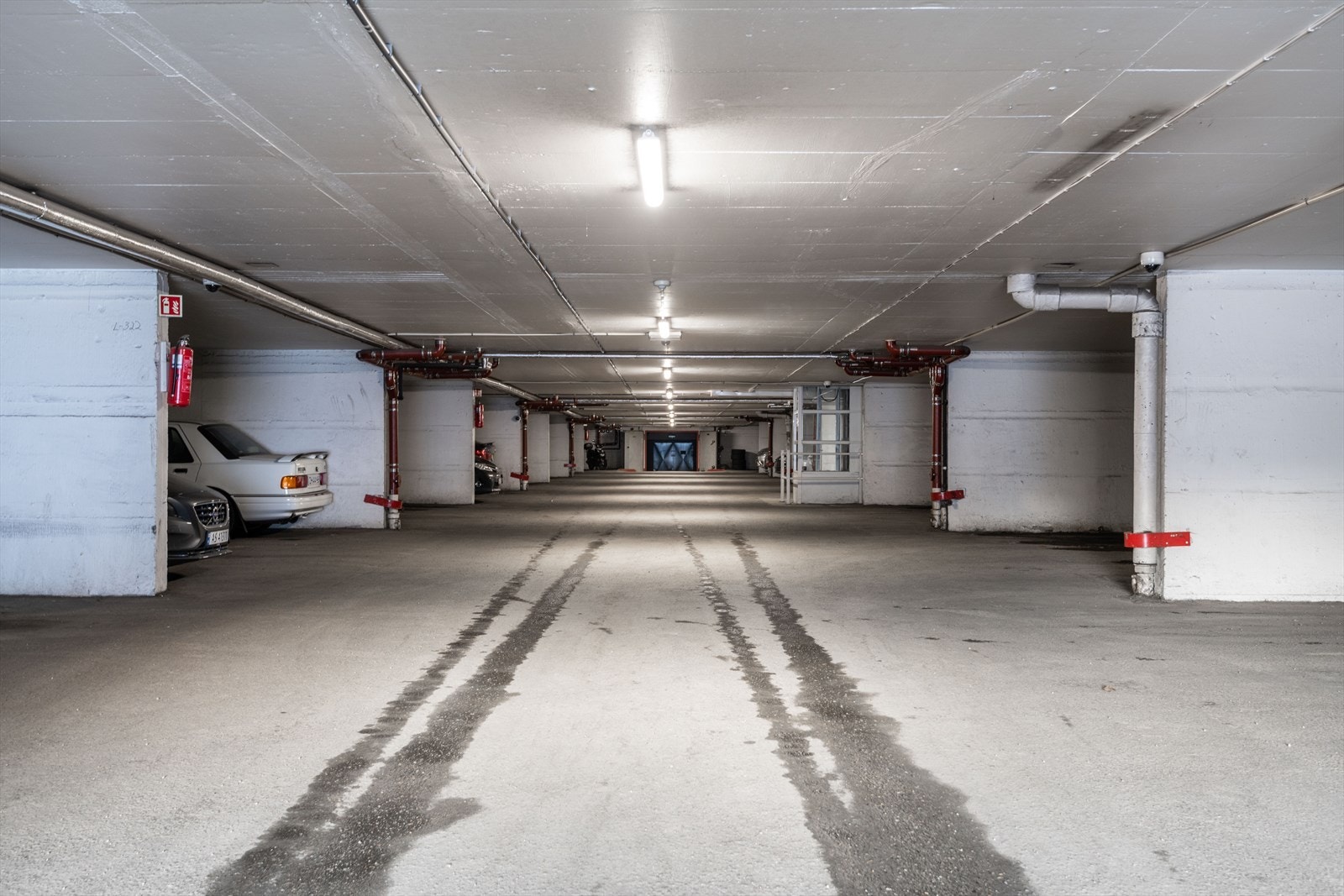 Leiligheten disponerer en parkeringsplass i felles garasjeanlegg under blokken. Her går det også heis opp til leilighetens etasje. Galleribilde