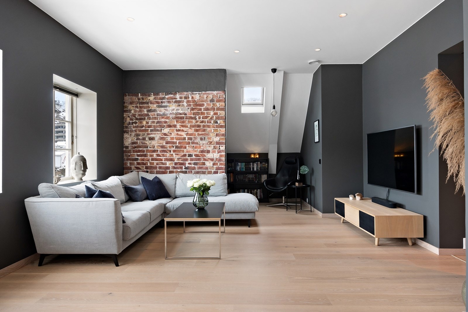 Teglsteinvegger gir en varm, industriell følelse som komplimenterer det moderne interiøret. Galleribilde