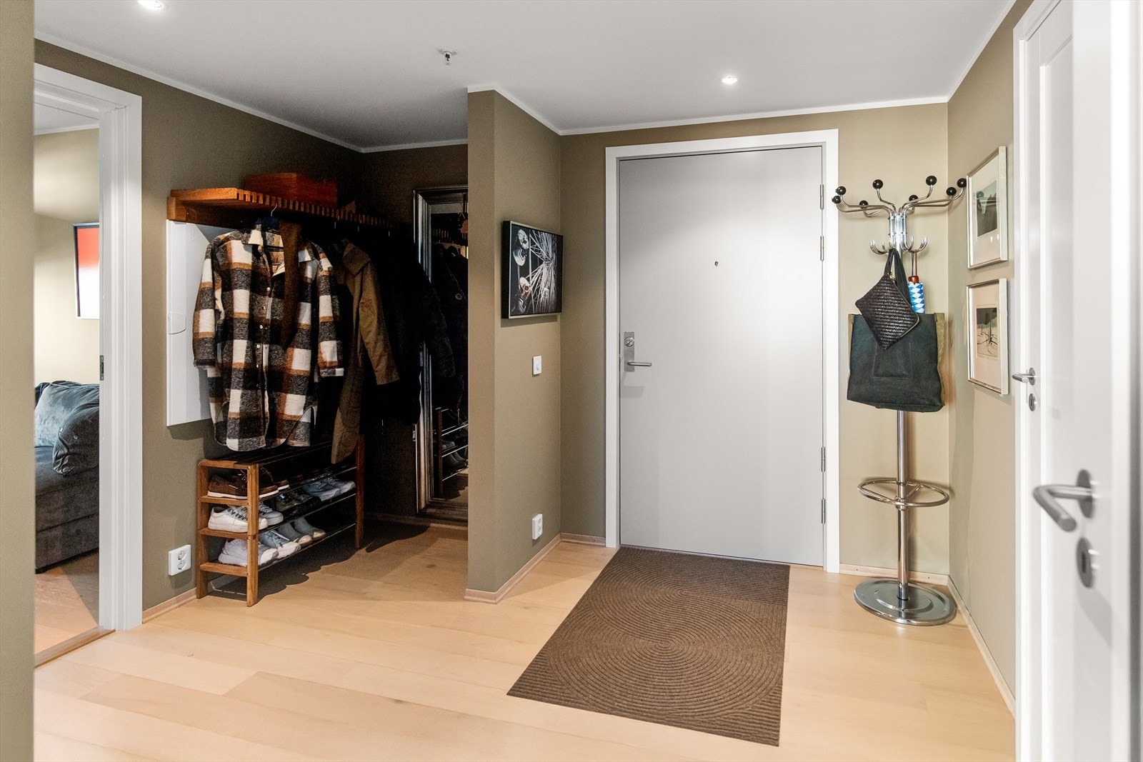 I en nisje ved inngangsdøren er det montert Skagerak Cutter teakhylle, og på veggen inn mot kjøkkenet er det montert dørcalling med åpner. Galleribilde