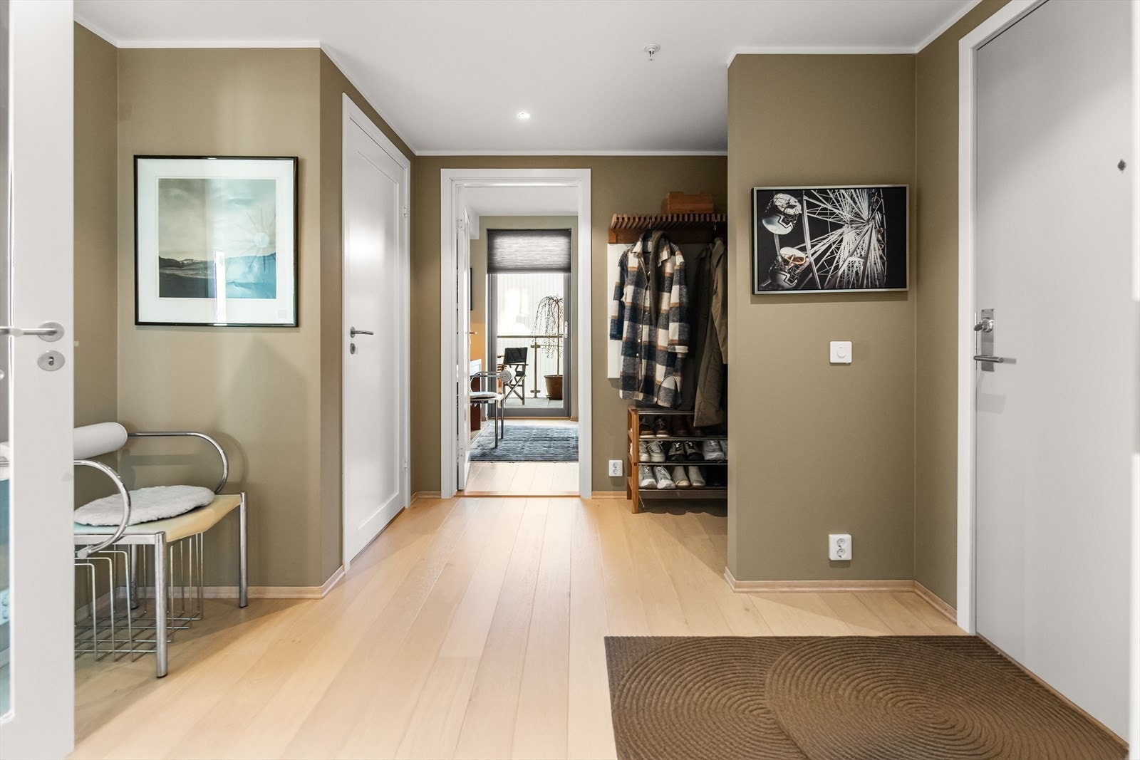 En innbydende entré med malte, slette vegger, downlights i himlingen og enstavs parkett på gulvet. Galleribilde