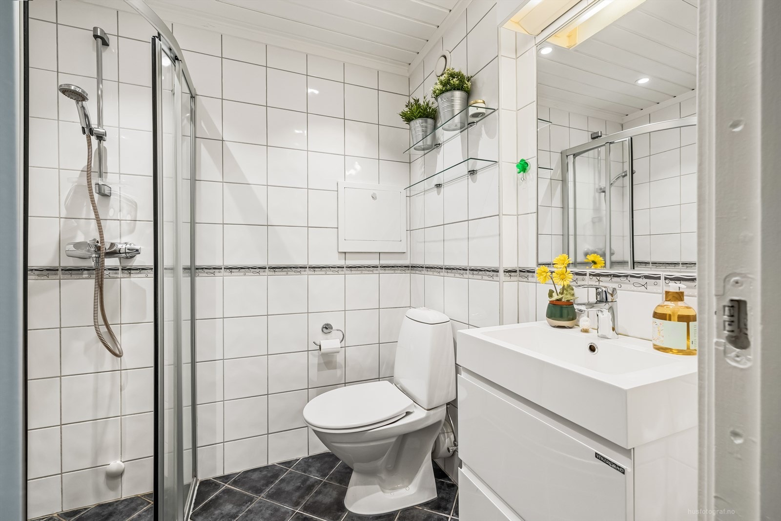 Rommet har innredning med nedfelt servant, toalett, dusjvegger/hjørne og opplegg for vaskemaskin Galleribilde