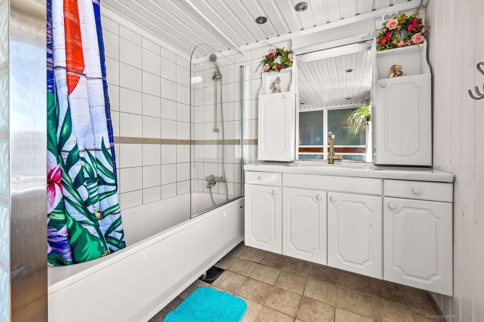 Gulvet er delvis flislagt og delvis belagt med parkett - Innredningen består av et vegghengt servantskap med heldekkende servant, ett-greps armatur, speil med overlys og praktisk skapplass Galleribilde