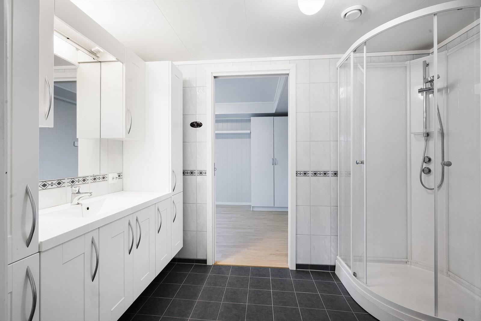 Det er et veggmontert toalett og dusjkabinett. Galleribilde